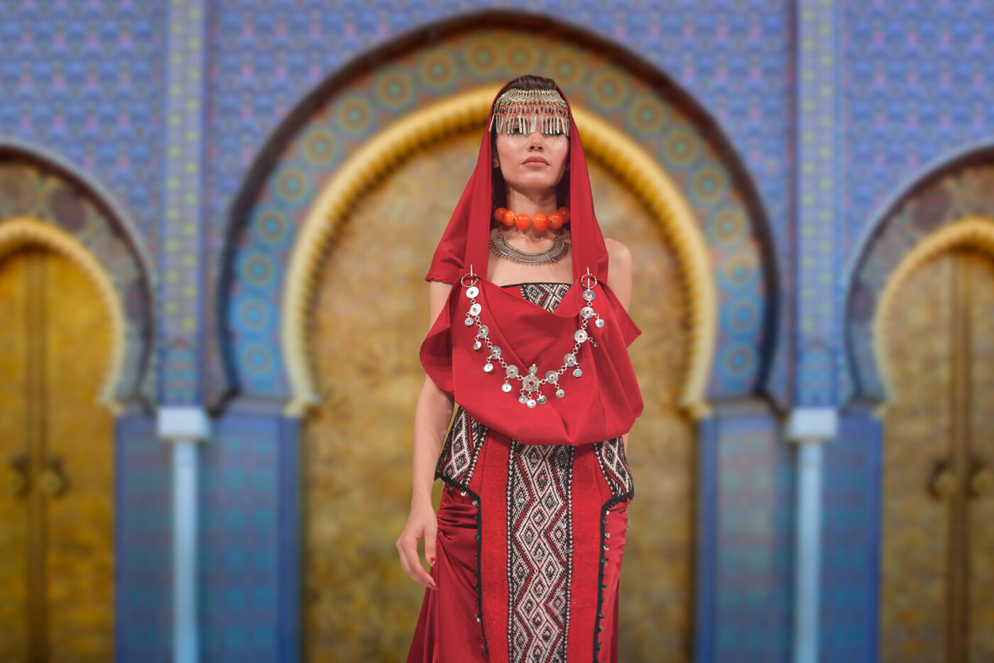 Tenue traditionnelle d’inspiration berbère devant une arche ornée