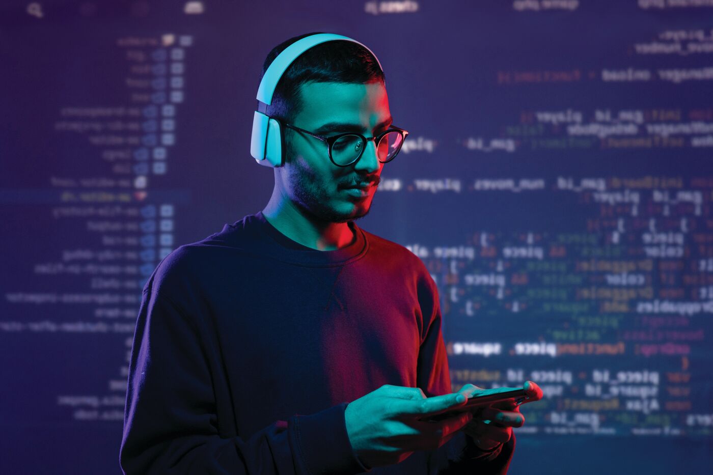 Programmeur avec écouteurs sous lumière néon