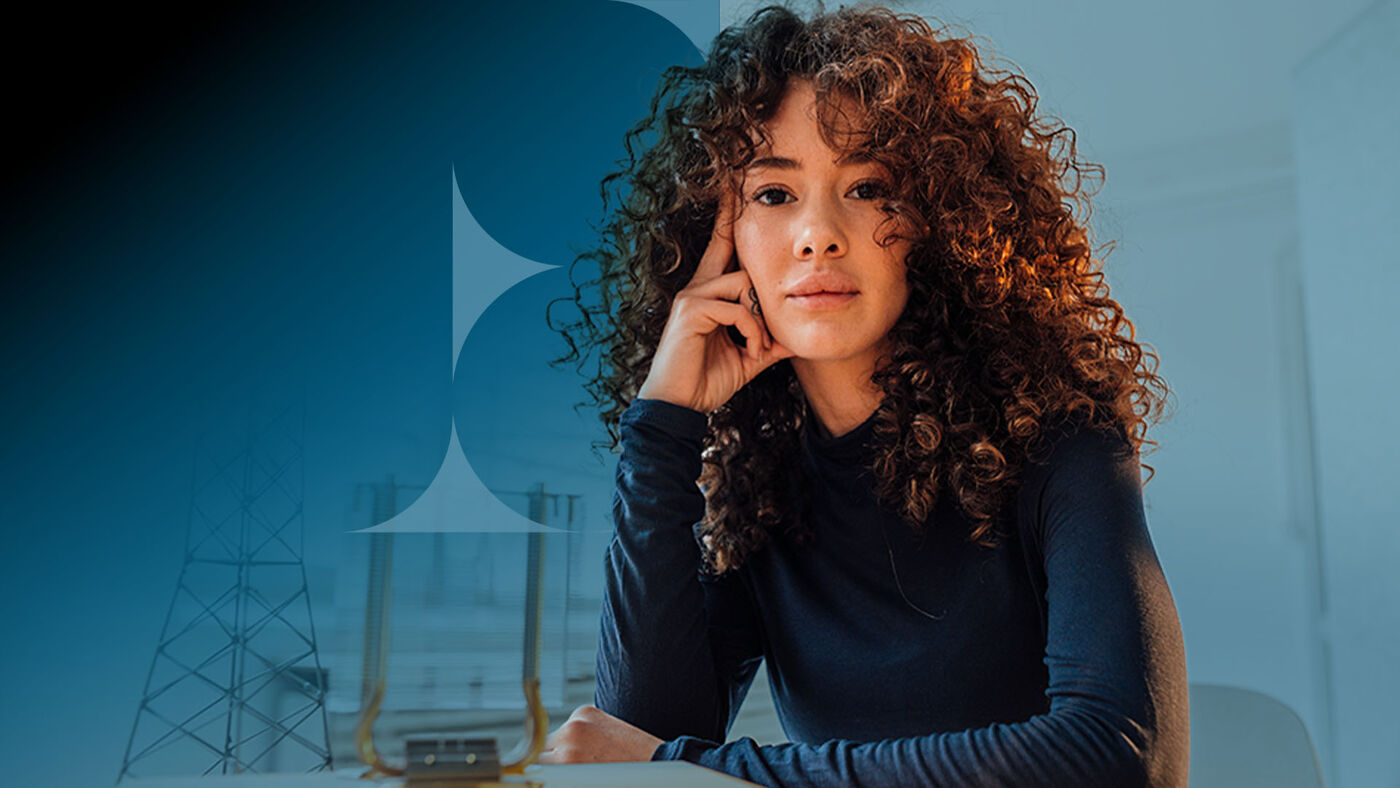A young woman with dark curly hair looks towards the camera with her hand resting on her head, set against a blue background with abstract shapes.