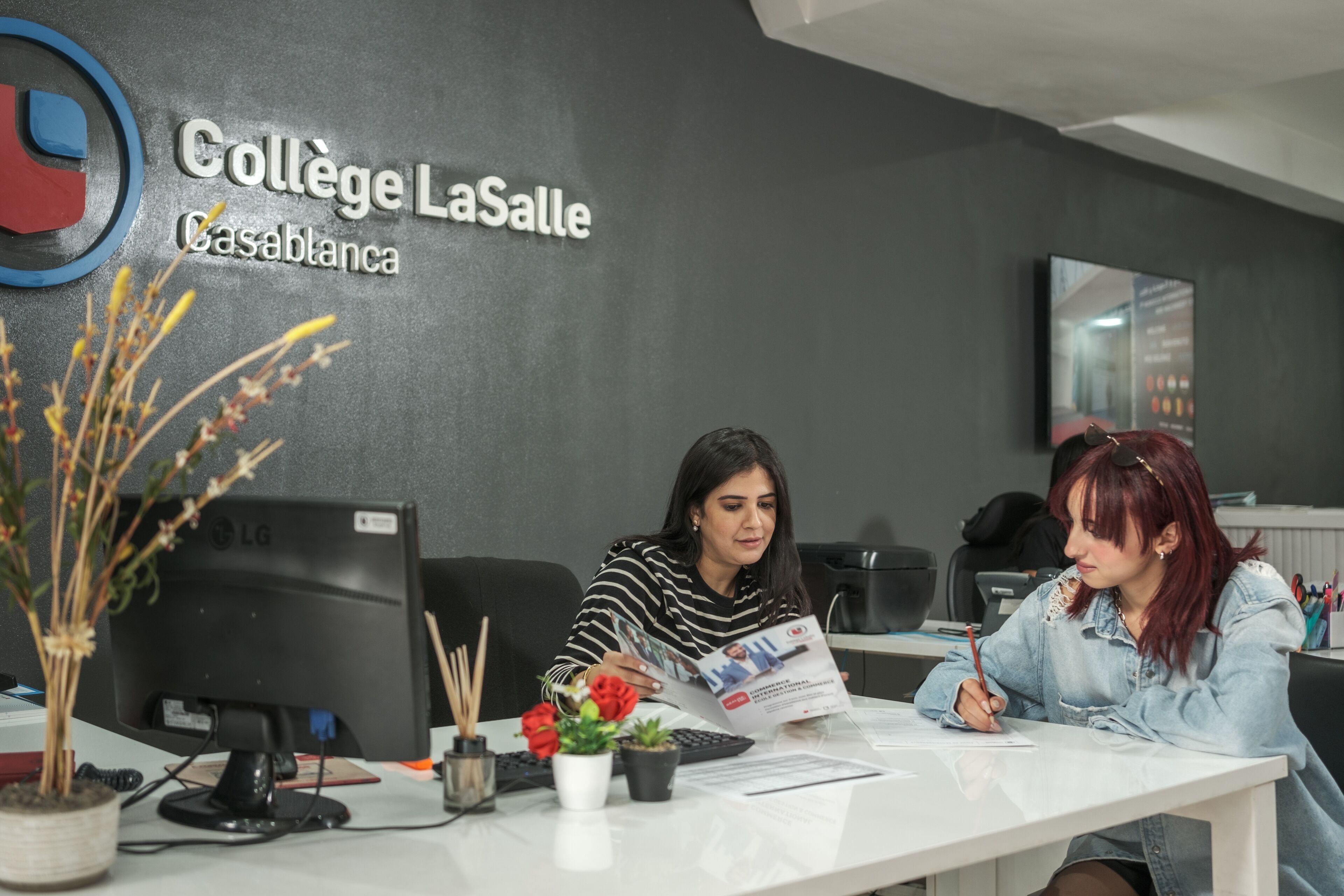 Students discussing educational materials at the Collège LaSalle Casablanca's consultation desk.