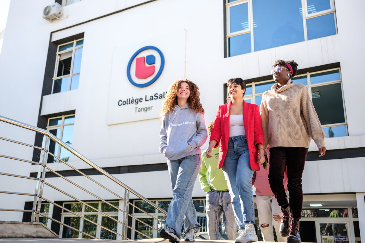 hree happy students walking together outside the College LaSalle building in Tangier.