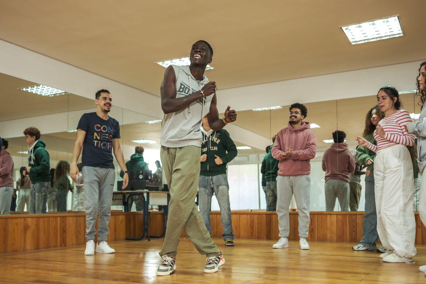 Energetic students participating in a lively dance session in a studio, expressing joy through movement.