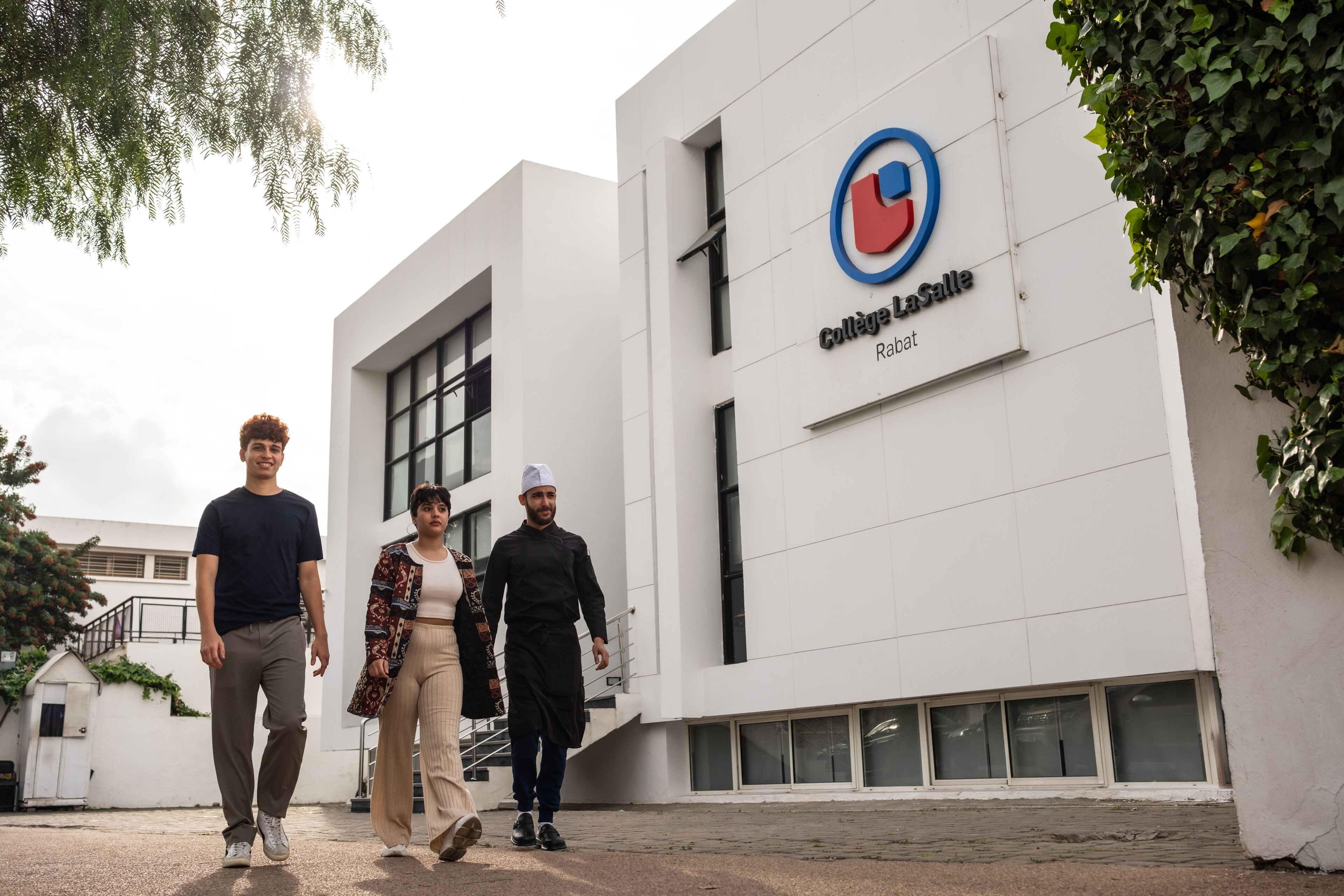 Three students exit Collège La Salle in Rabat, the diverse group reflecting the school's inclusive environment.