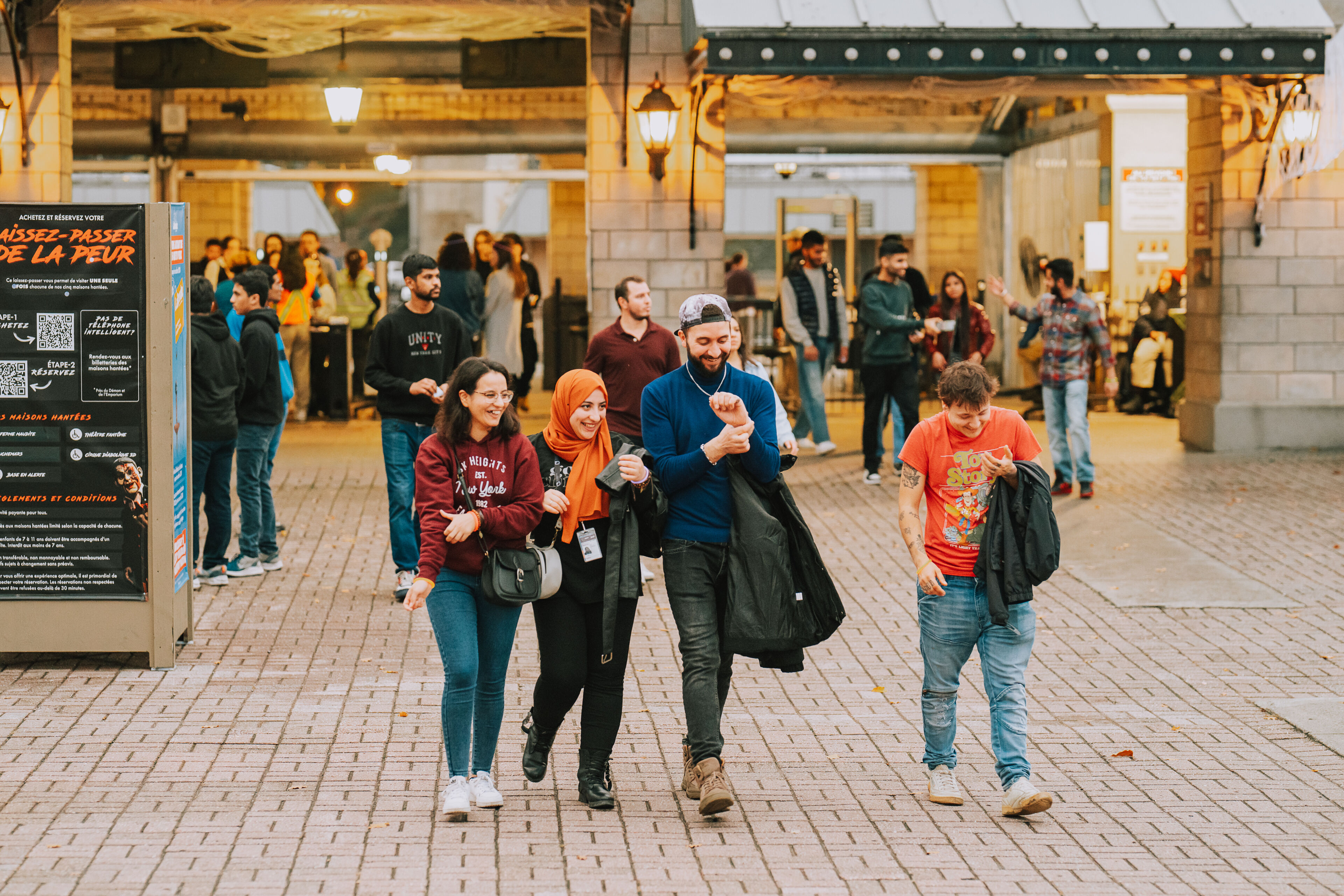 A group of friends enjoy a leisurely walk through the city's vibrant streets as evening falls.