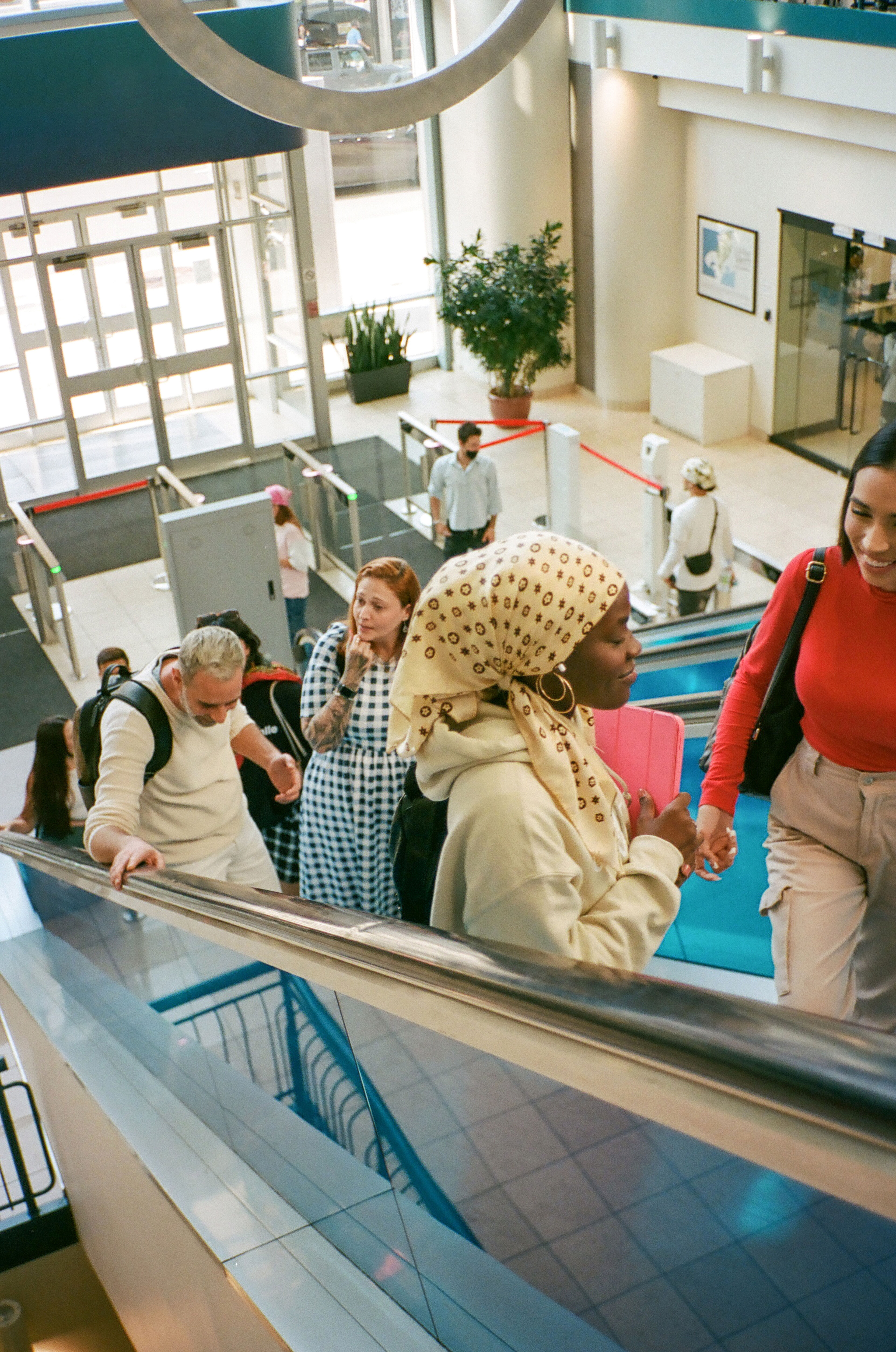 Friends laugh together on an escalator, a slice of daily life in a vibrant setting.