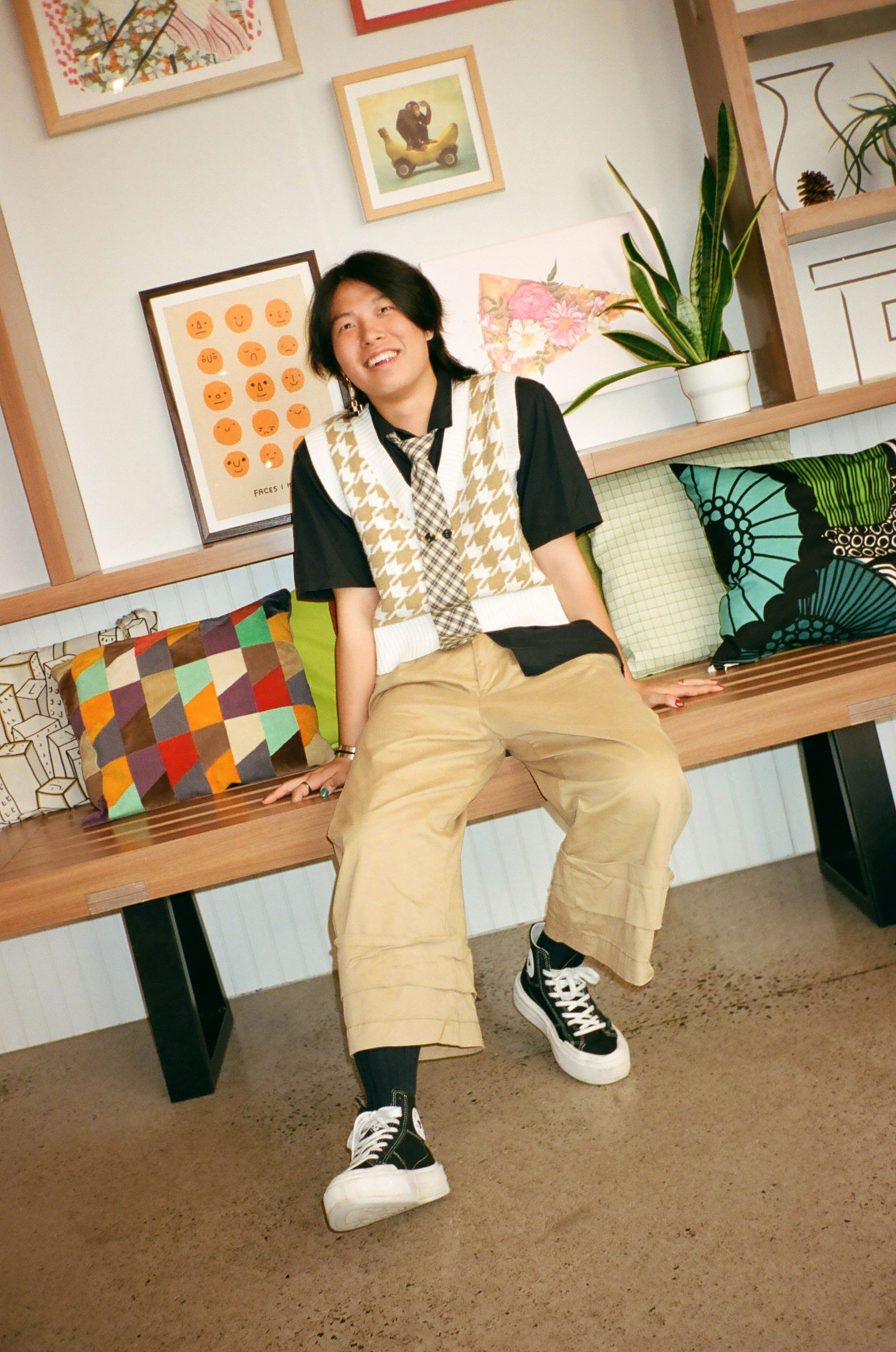 A student relaxes on a bench, showcasing laid-back campus life with a mix of study and leisure.