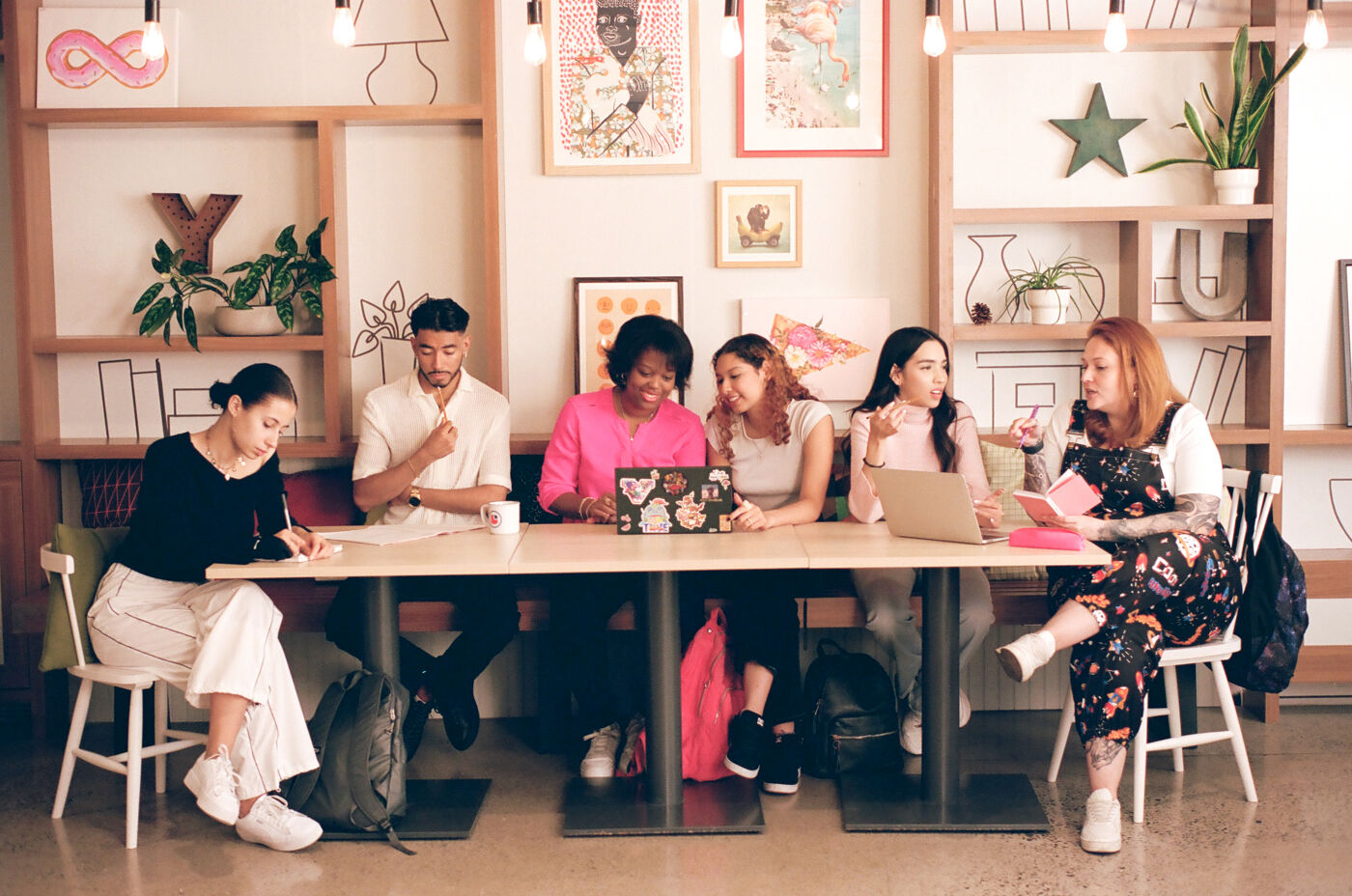 A group of diverse individuals engaged in a lively brainstorming session in a vibrant café setting.