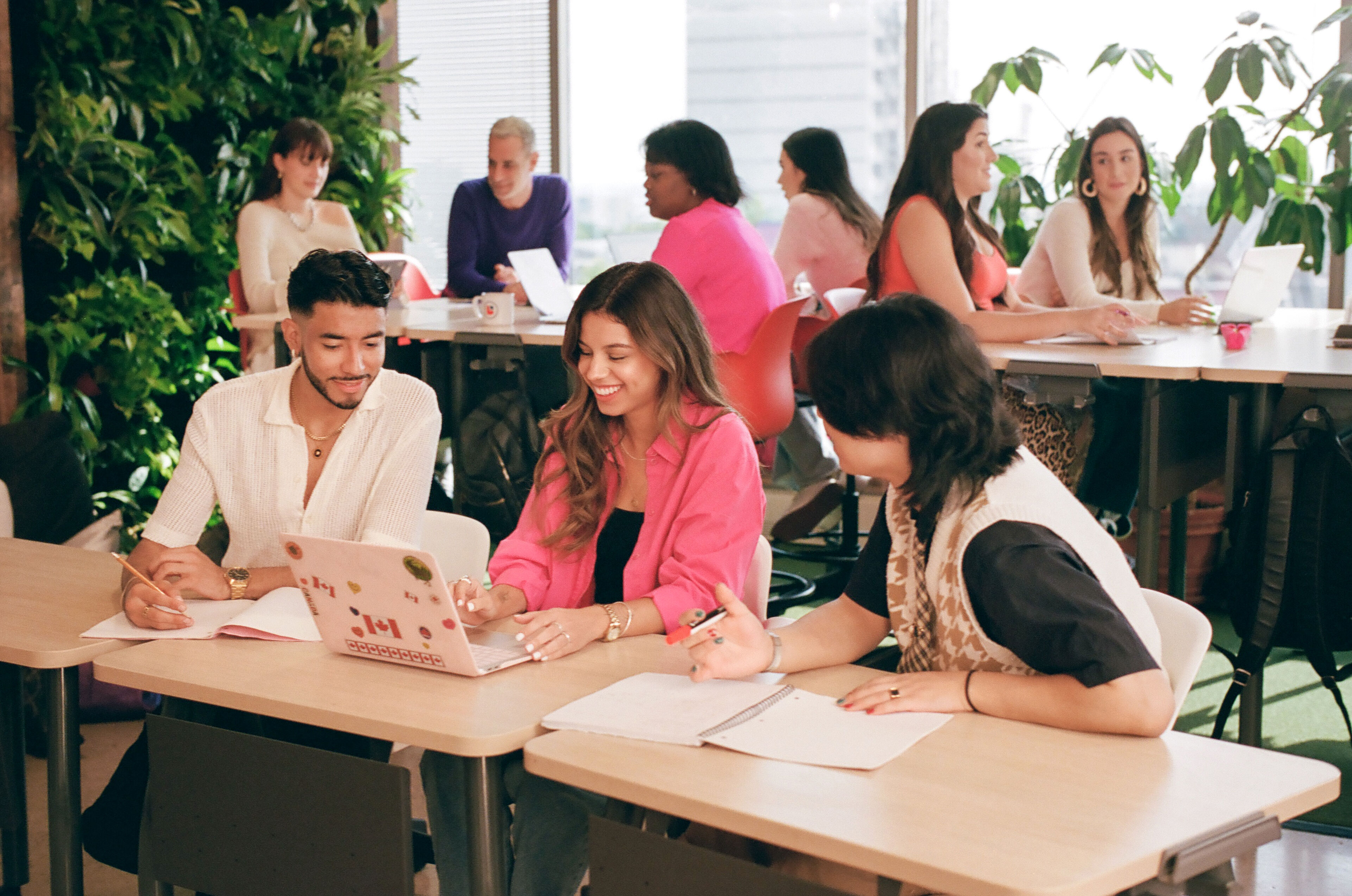 A lively team meeting with laptops and notes at a well-lit table.