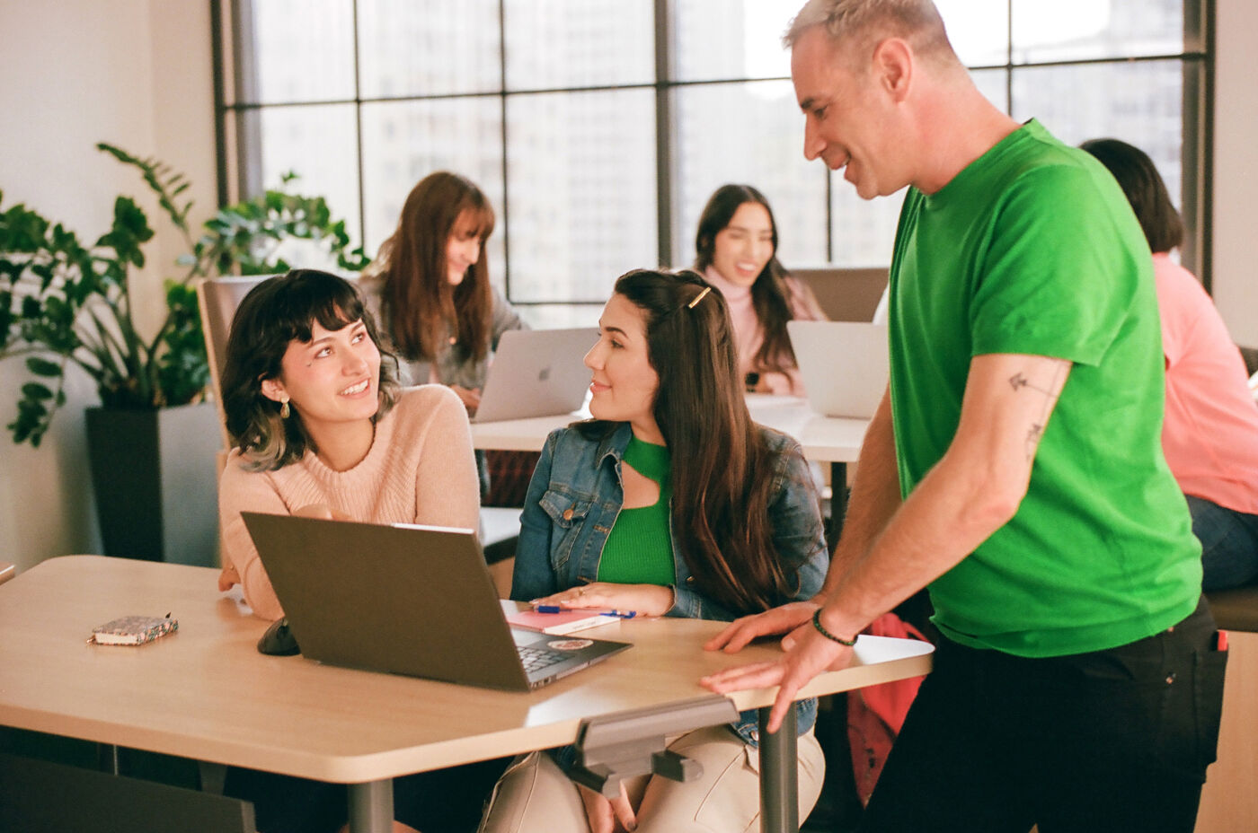 Students engage in a lively discussion with a teacher during a collaborative learning session.