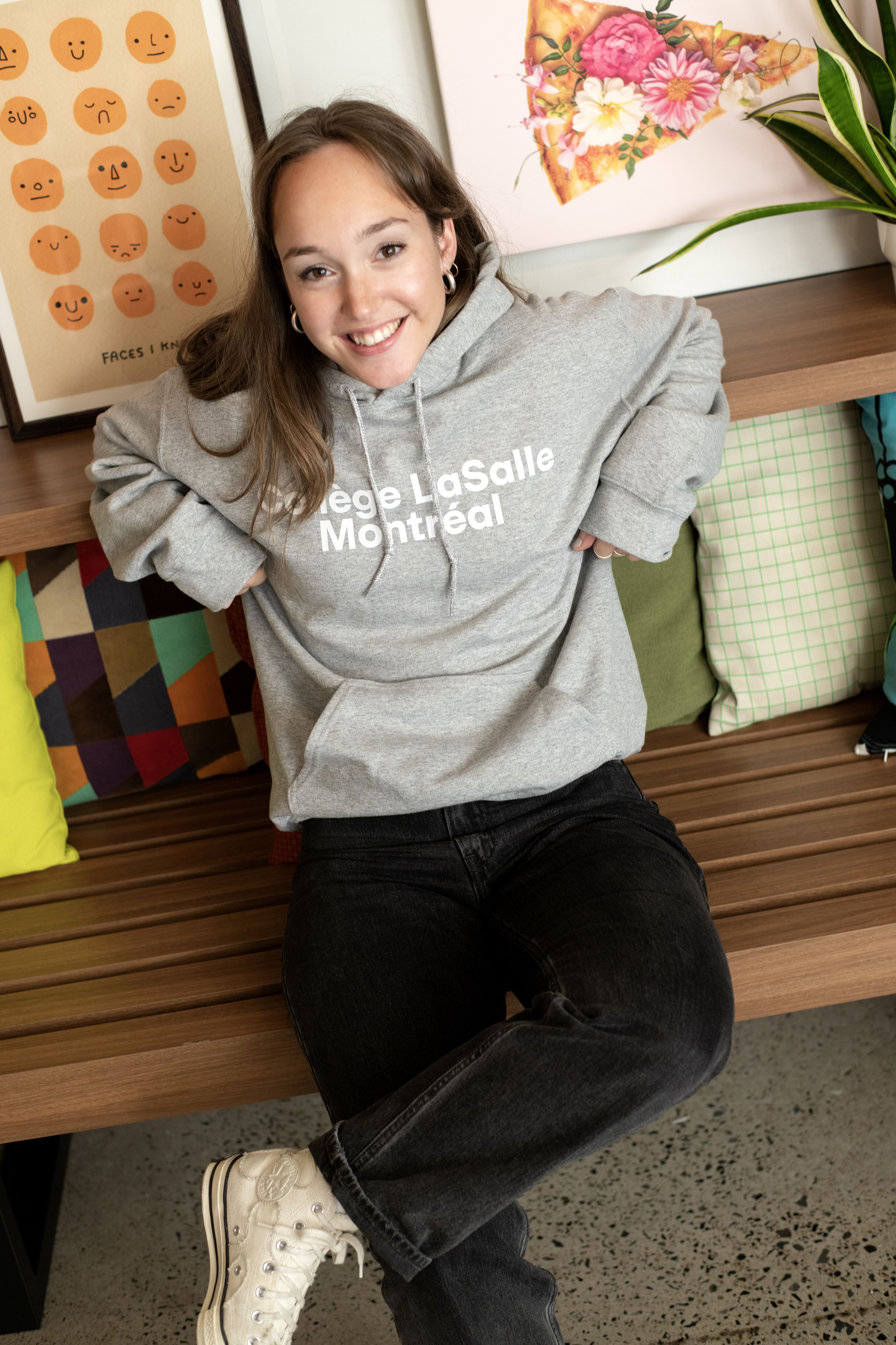A happy student lounges in a cozy campus corner, showcasing college pride.