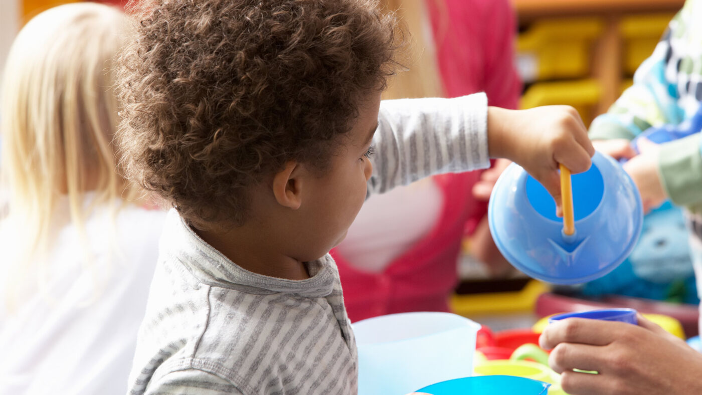 A young girl focused on assembling colorful building blocks, expressing creativity and concentration.