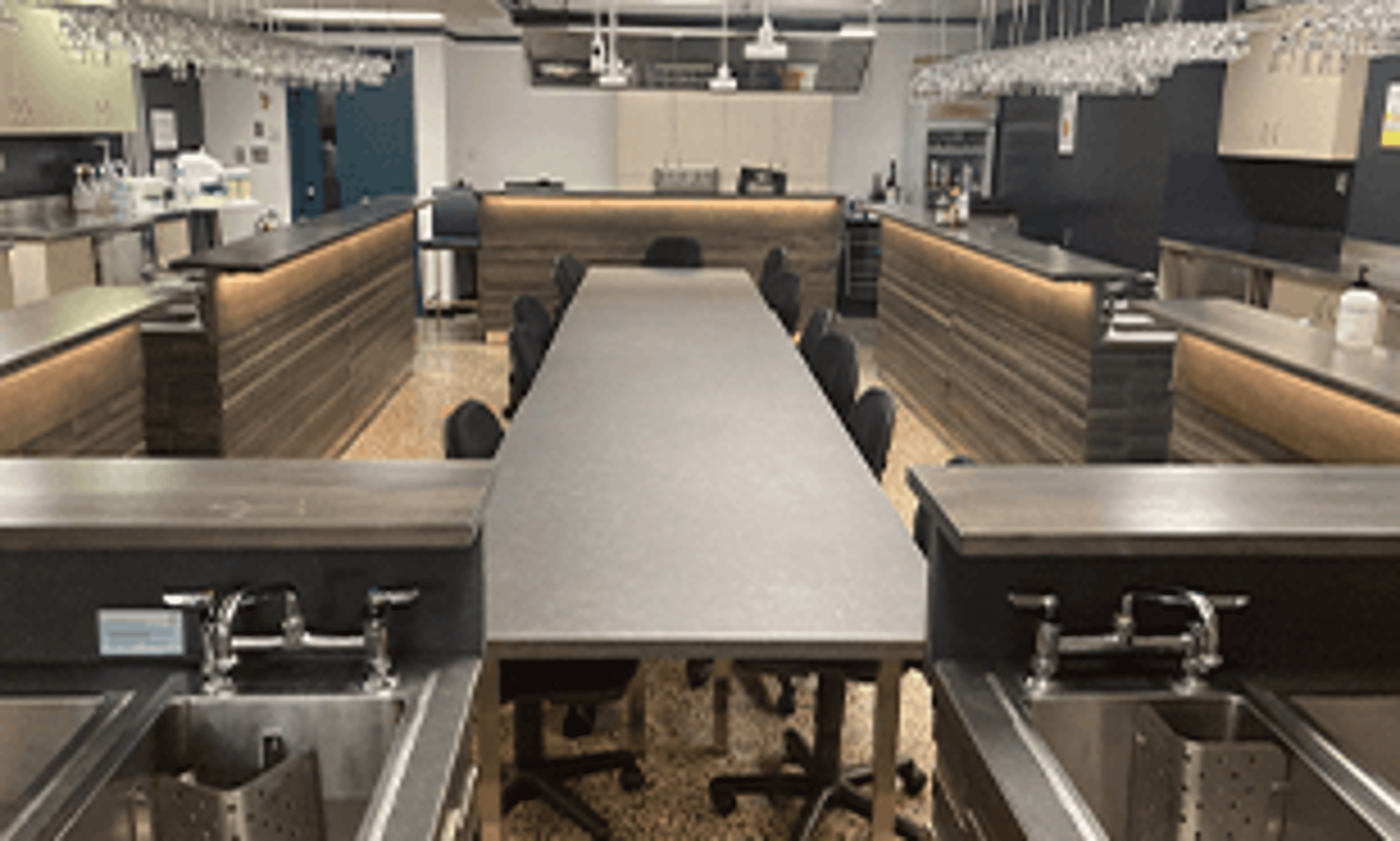 A hairdressing training environment with salon stations, chairs, and mirrors set up for practical learning.