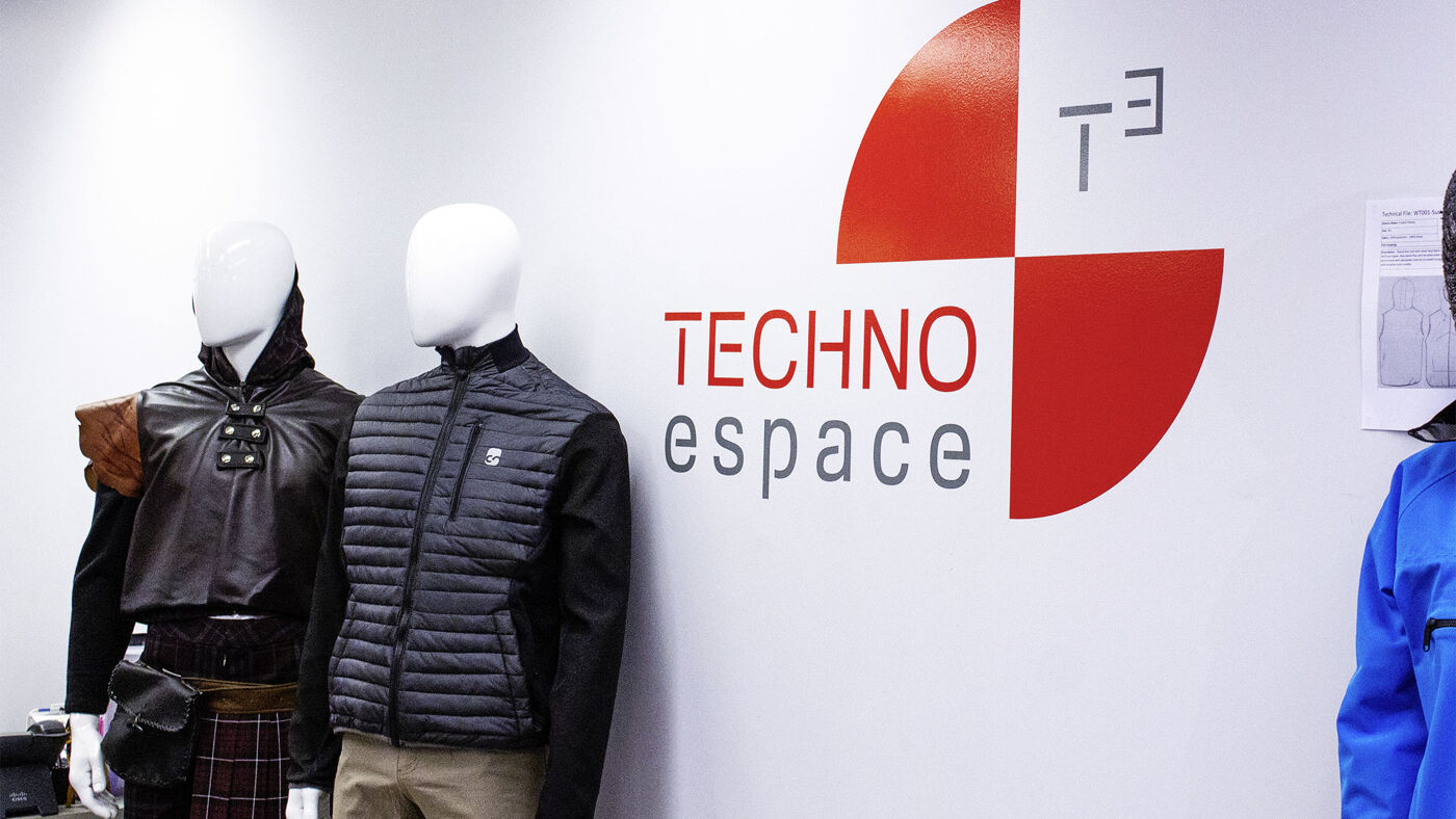 Mannequins showcasing modern outerwear in a "Techno Space" branded retail environment.