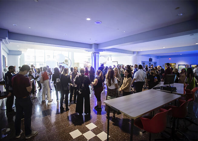 A lively gathering of professionals engaged in conversation at an indoor networking event.