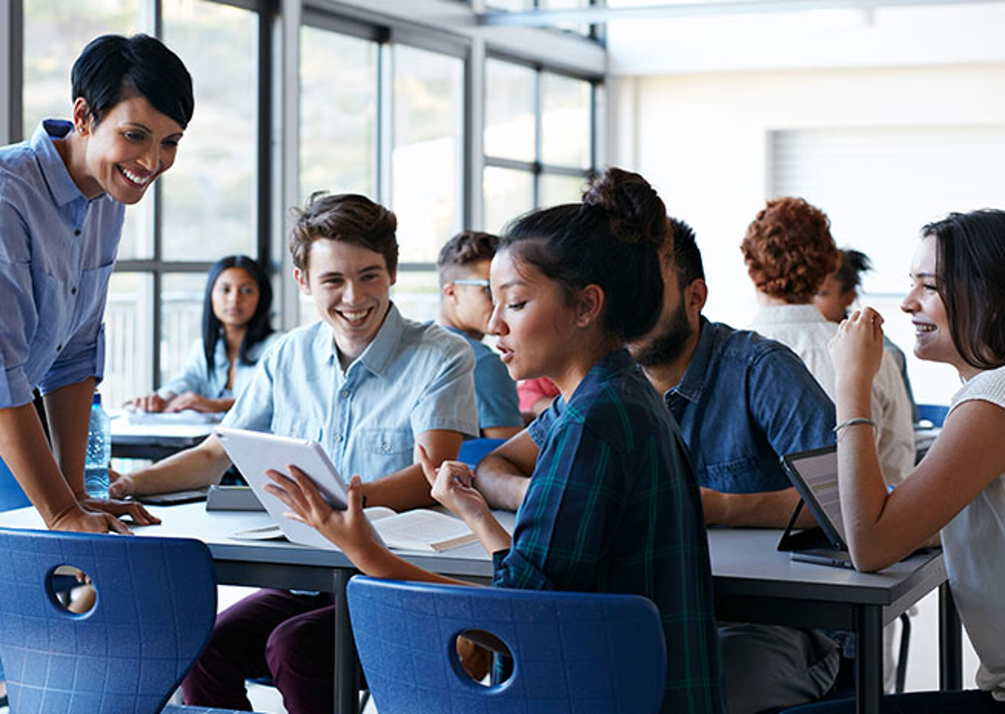 A teacher interacting with students during a lively classroom discussion, highlighting an engaging educational environment.