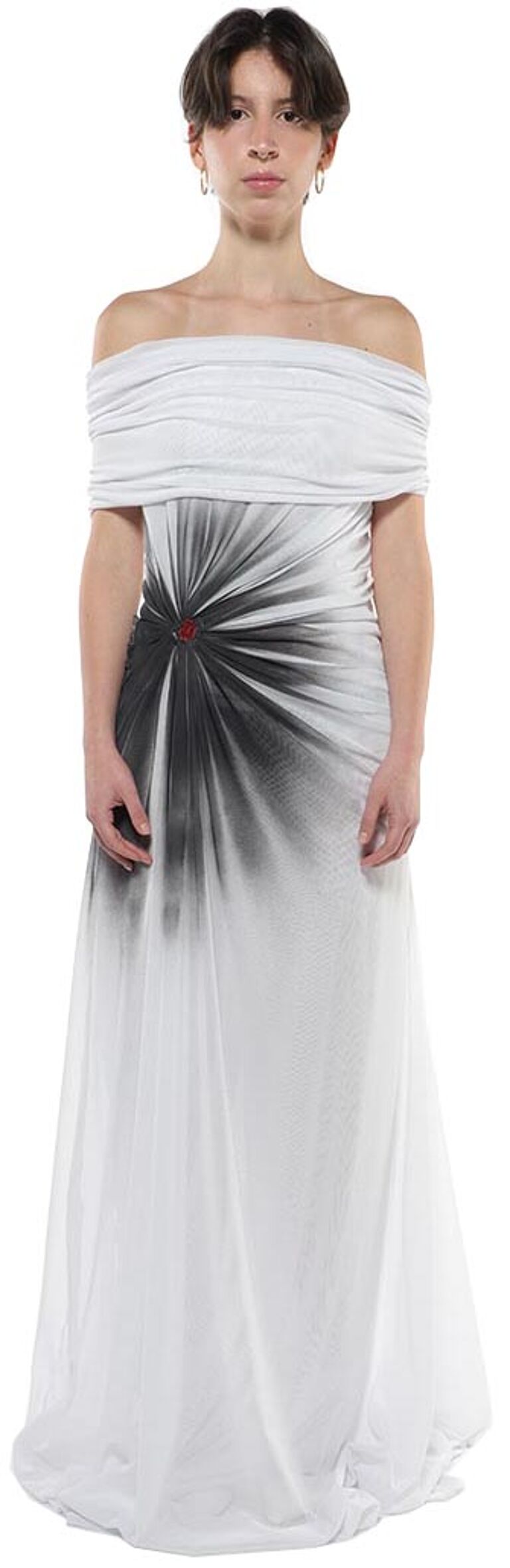 A woman with short dark hair wears a white off-the-shoulder maxi dress with a dark gray sunburst design centered on the bodice.