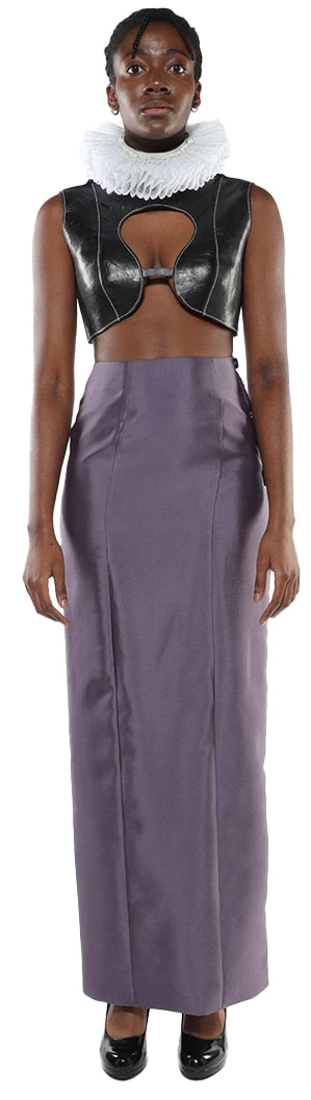 A dark-skinned model wears a black leather crop top over a white ruffled collar, paired with a long, slate-purple skirt and black heels.