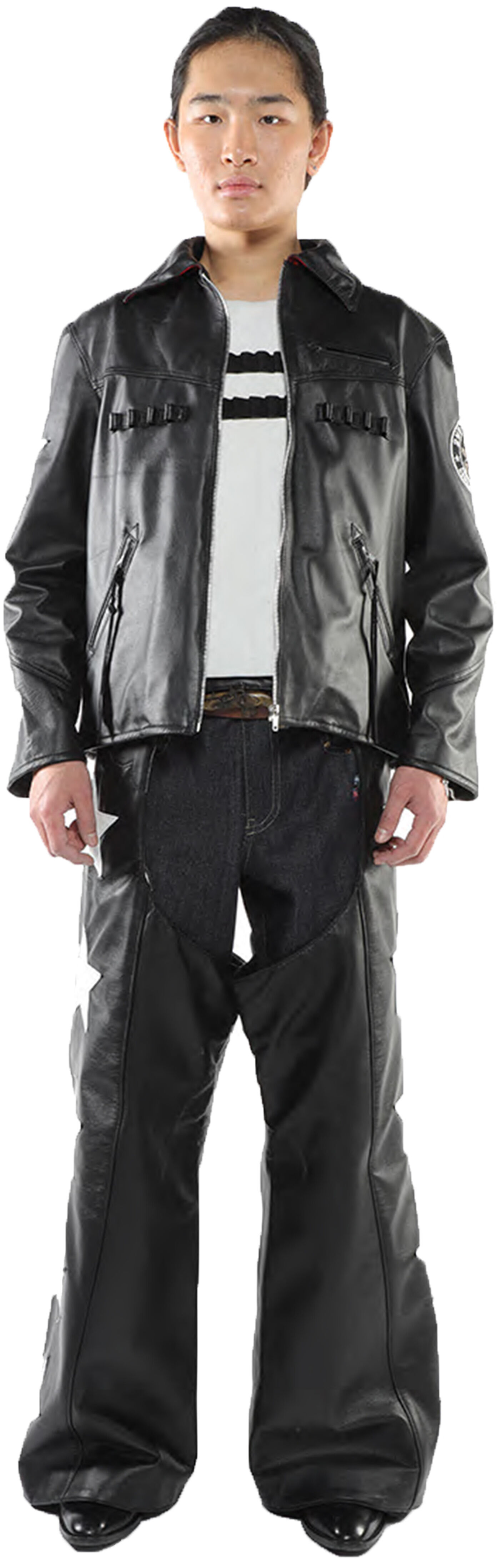 A person wearing a black leather jacket and matching pants stands against a white background.