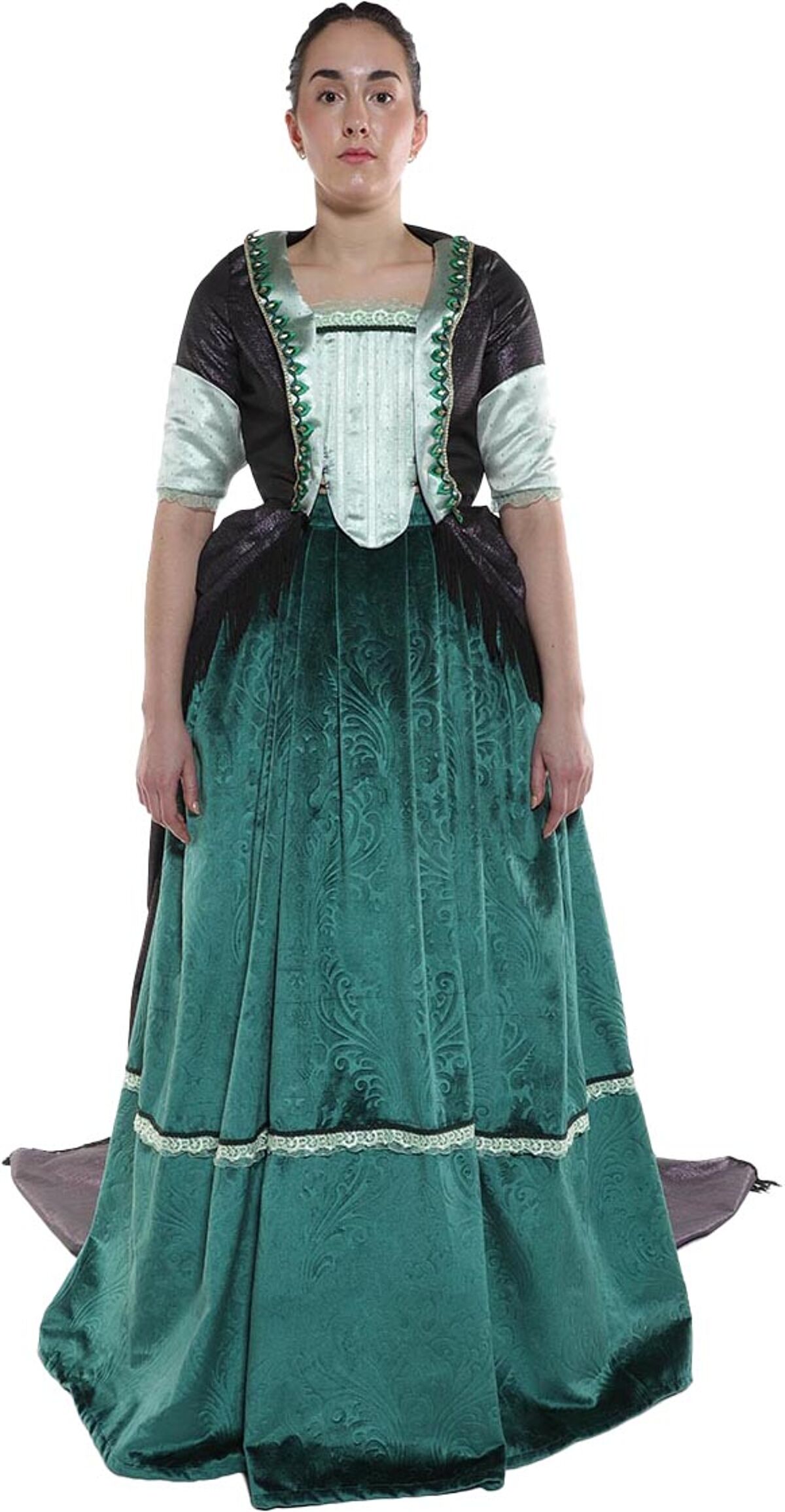 A woman in a teal velvet gown with a dark green bodice and a light green vest stands against a white background.