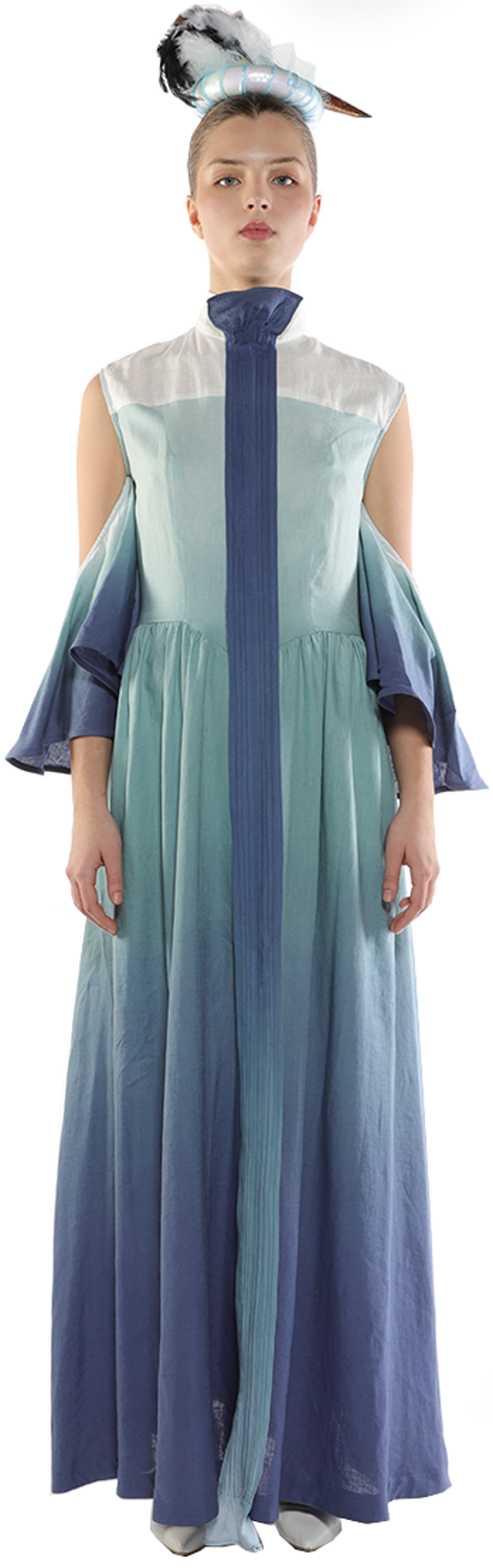 A model wears a long ombre dress with cold-shoulder sleeves and a unique headpiece.
