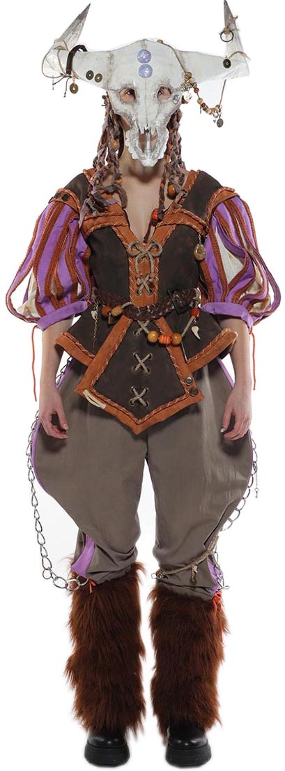 Full body shot of a person in a costume with a skull mask, layered clothing, and furry leg warmers.
