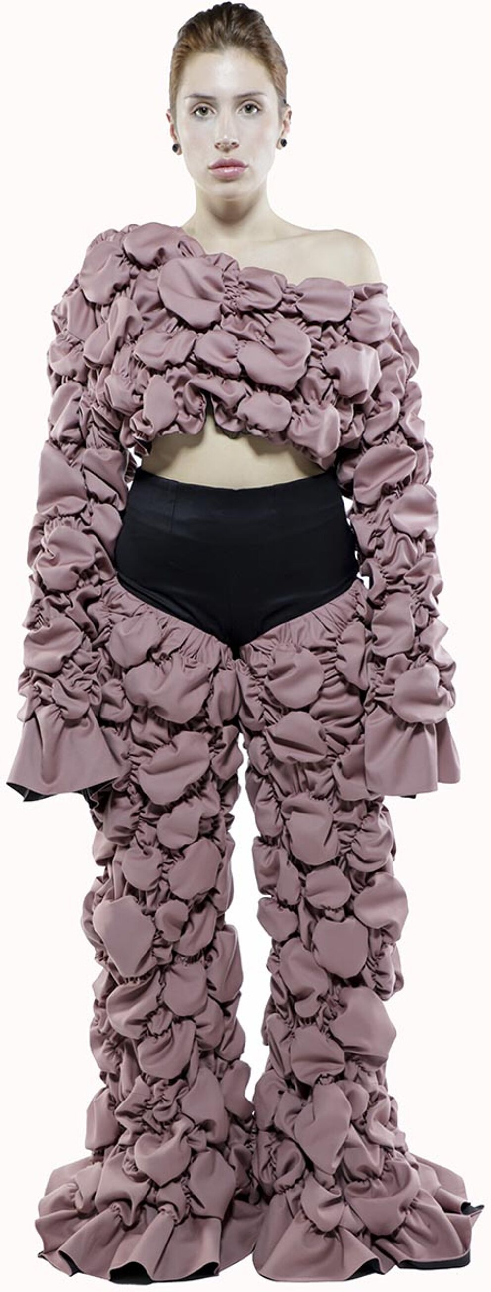 A model wears a mauve, ruffled, off-the-shoulder top and matching pants with black shorts underneath.