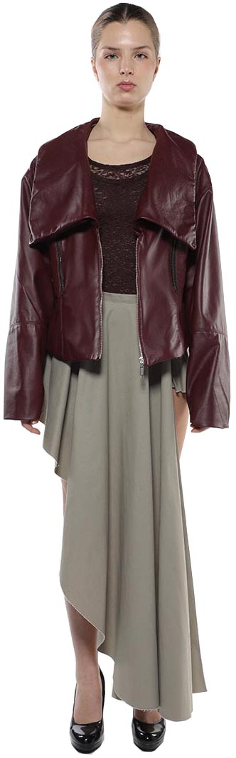 A woman with light skin and dark hair is wearing a maroon leather jacket and a light beige asymmetrical skirt, black high heels and her hair is pulled back.
