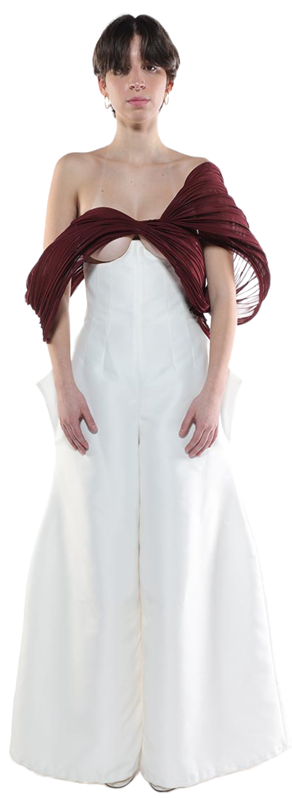 A young woman with short dark hair is modeling a white wide-leg jumpsuit with a dark maroon pleated fabric draped over her shoulders.