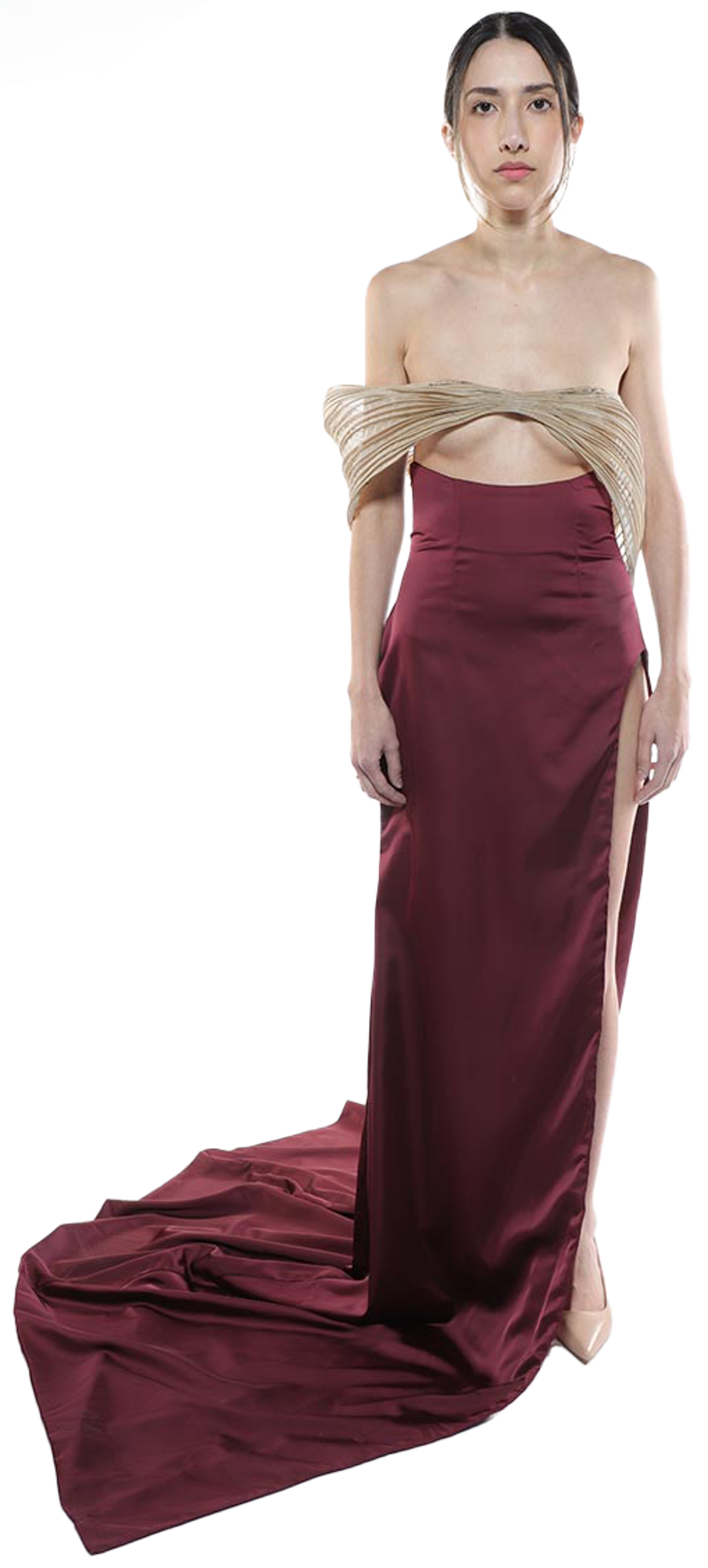 A woman with dark hair pulled back in a sleek ponytail poses in a long, burgundy gown with a beige, pleated off-the-shoulder top and a high leg slit, against a white background.
