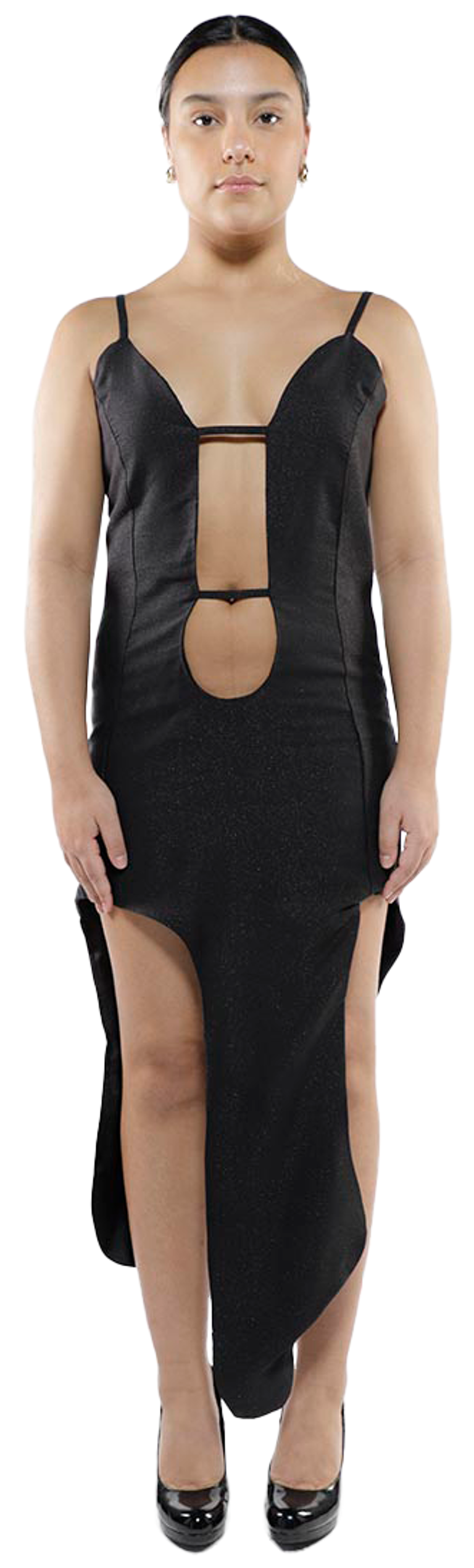 A young woman with tan skin and dark hair pulled back in a bun stands facing forward in a black, low-cut, asymmetrical dress with a high slit, wearing black heels.