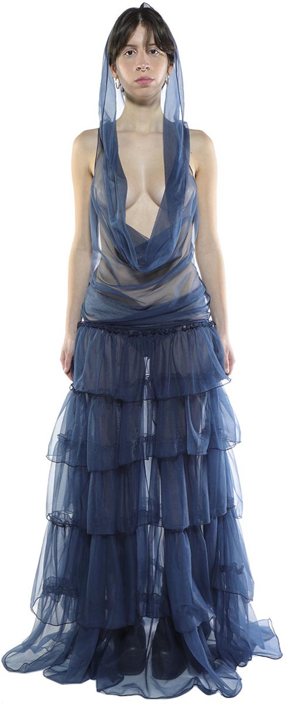A woman with dark hair is wearing a long, layered, sheer blue dress with a cowl neck and a hood.