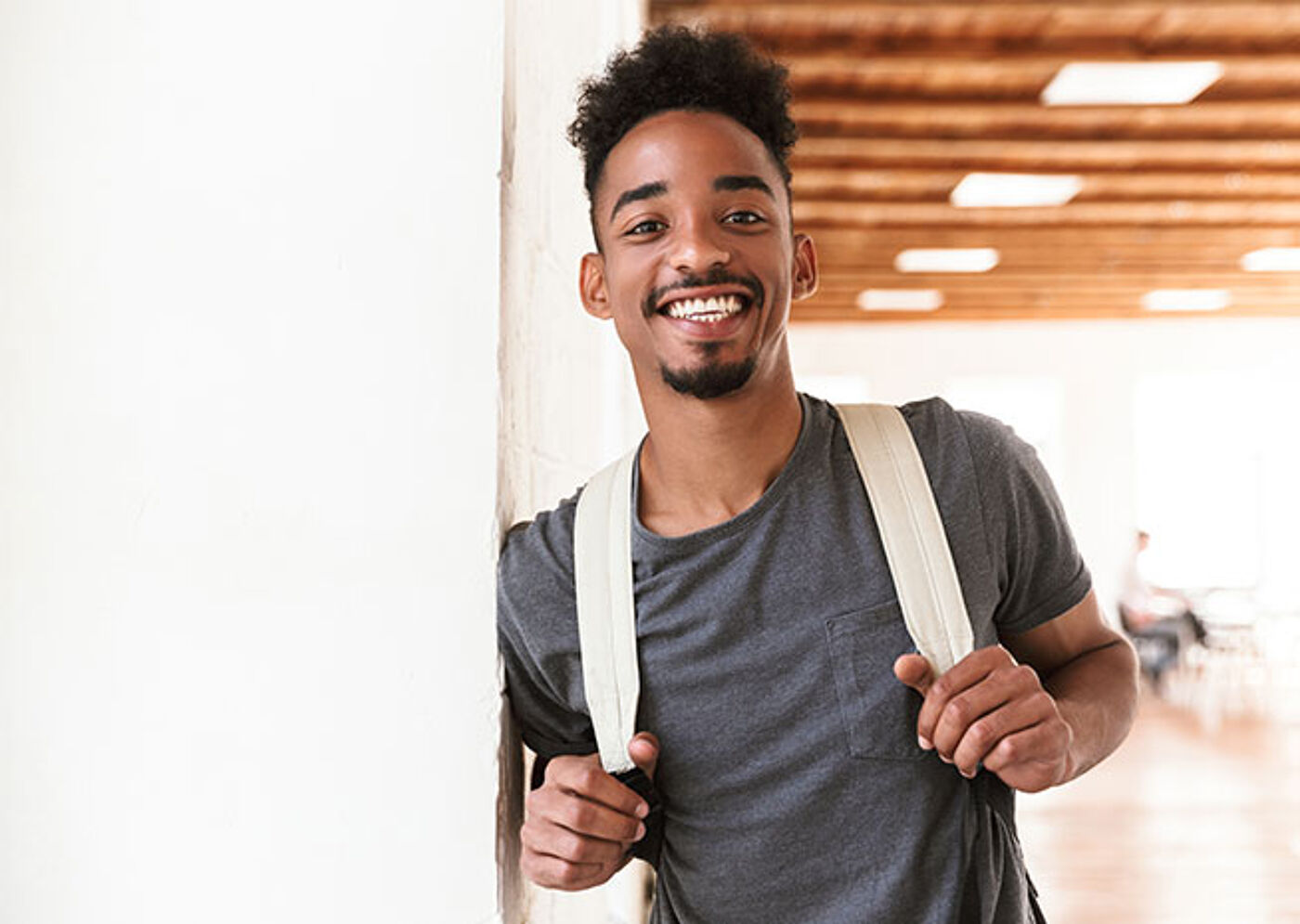 Jeune homme souriant avec un sac à dos