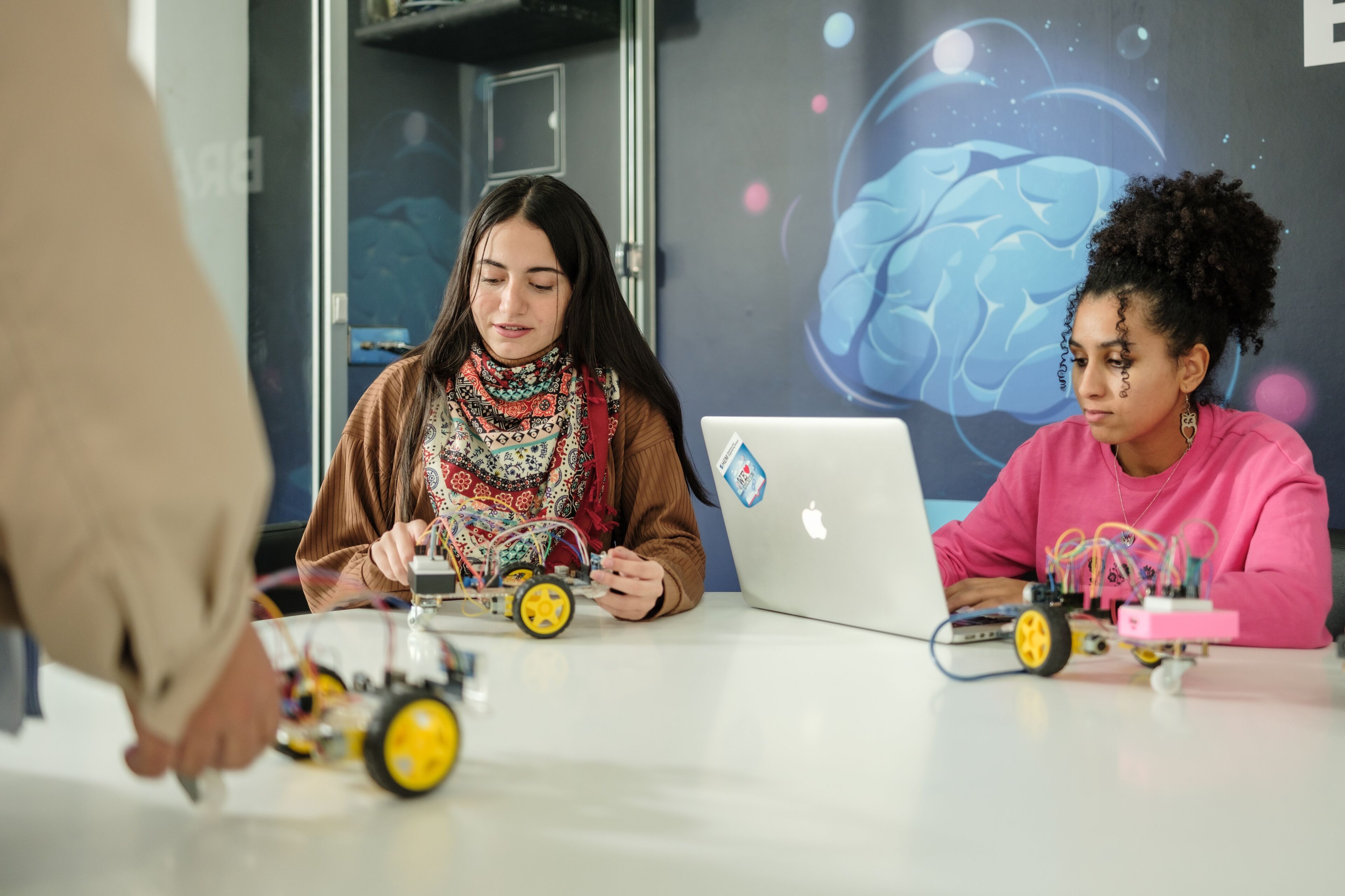 Deux étudiants travaillant sur des robots avec des ordinateurs portables dans une salle de technologie.