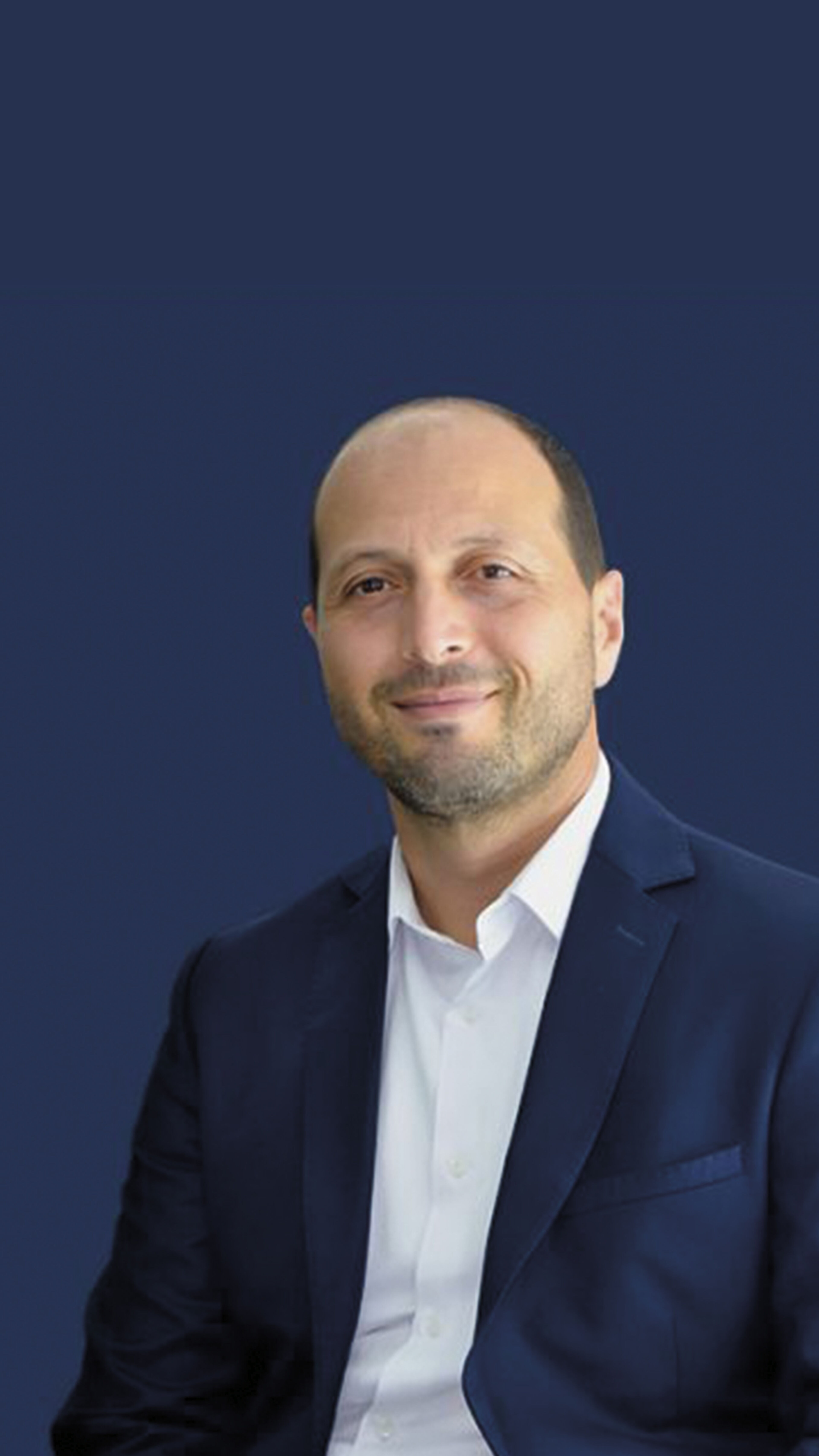 Youssef Bouabid est un lauréat du MBA Management Général / MBA International Paris. Il sourit en costume sur fond bleu, illustrant le professionnalisme.