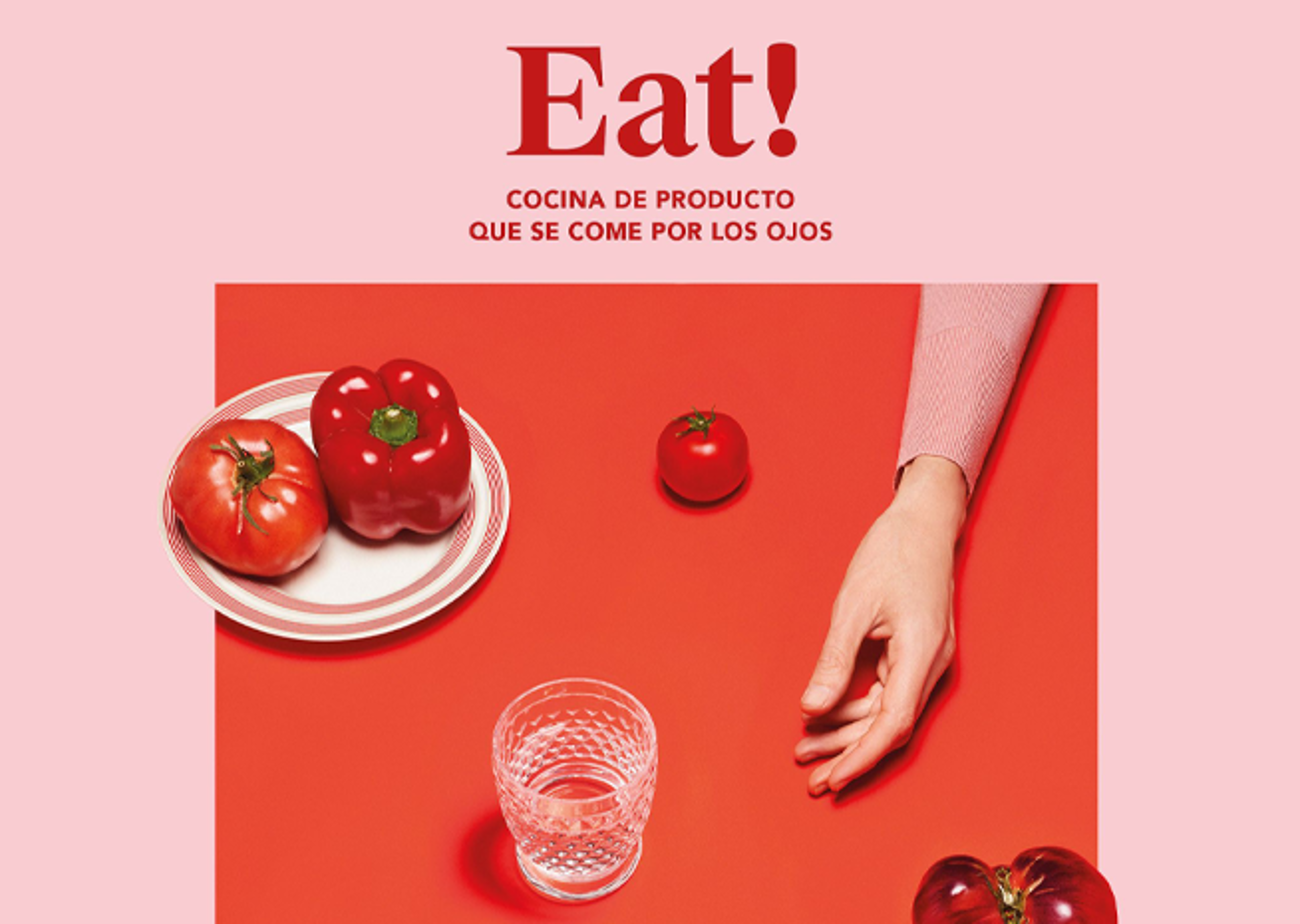 Una elegante disposición de alimentos con tomates y pimiento en un plato, un vaso y la mano de una persona, todo en una superficie roja con el texto "Eat!".