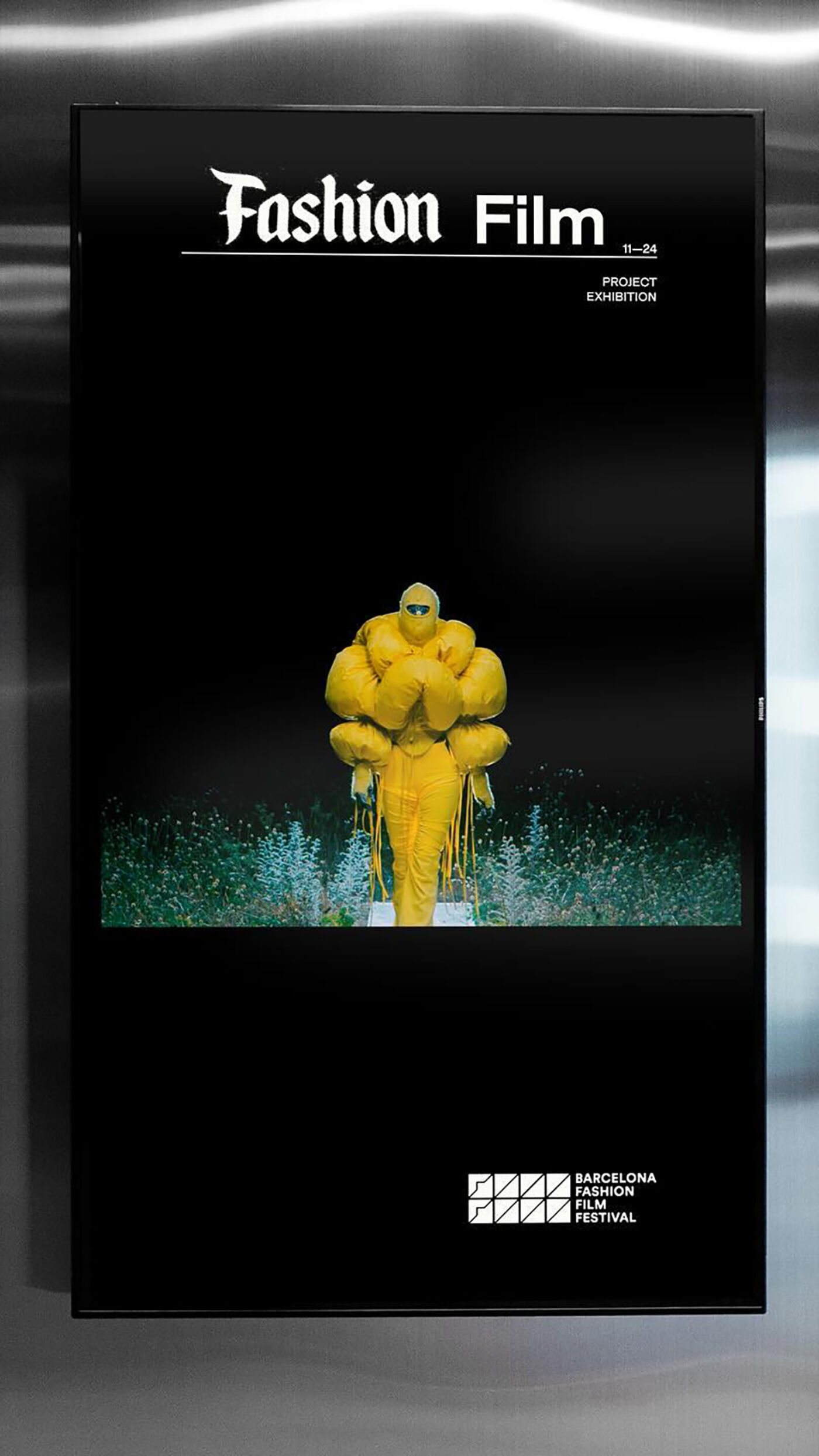 The picture features a yellow statue or sculpture of a person, possibly a man or a woman, with a large yellow ball or a yellow umbrella. The statue is displayed in a dark room, and the image is taken from a cell phone.