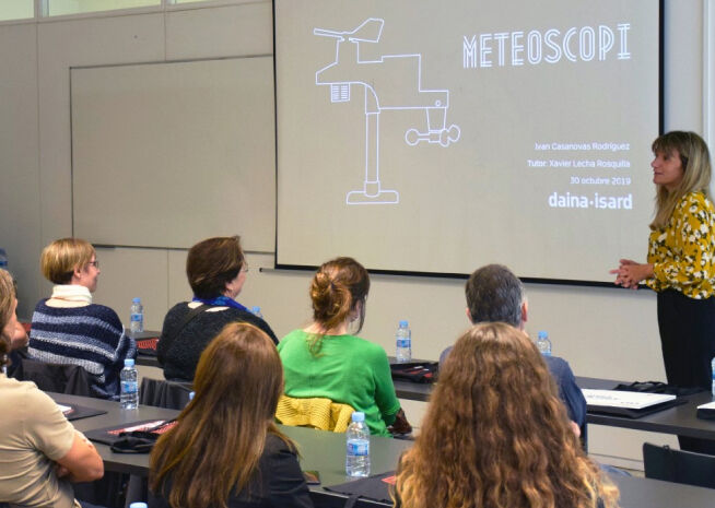 Una ponent interactua amb un públic atent durant una presentació meteorològica anomenada 'METEOSCOPI'.
