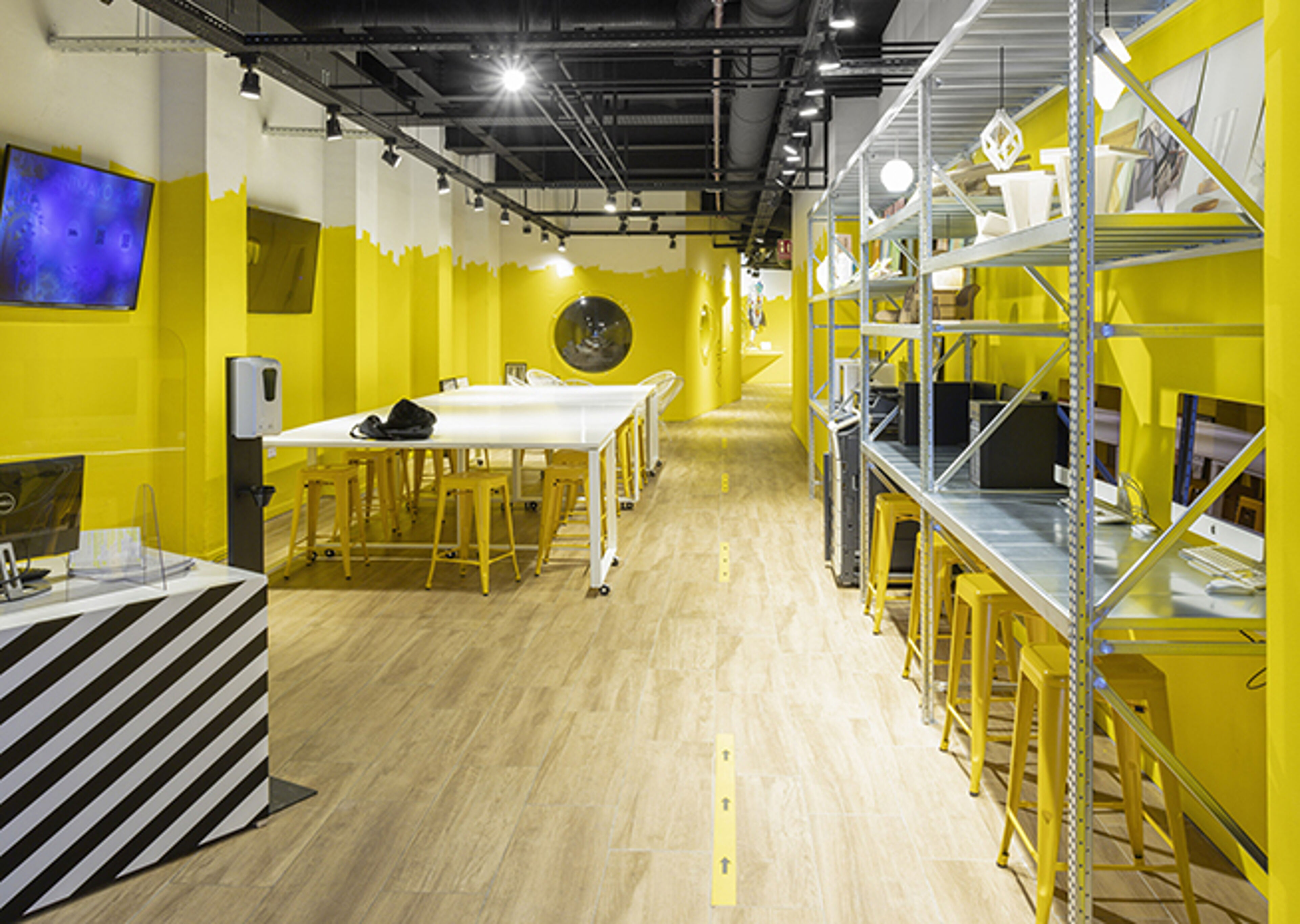 A dynamic workspace with bright yellow accents, modern furniture, and an open layout for collaboration.