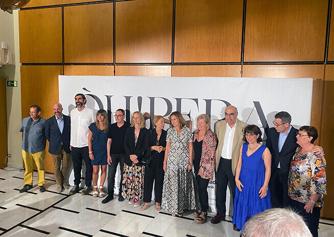 A diverse group of adults posing for a group photograph at a conference, in front of a backdrop with the word "LIBERA".