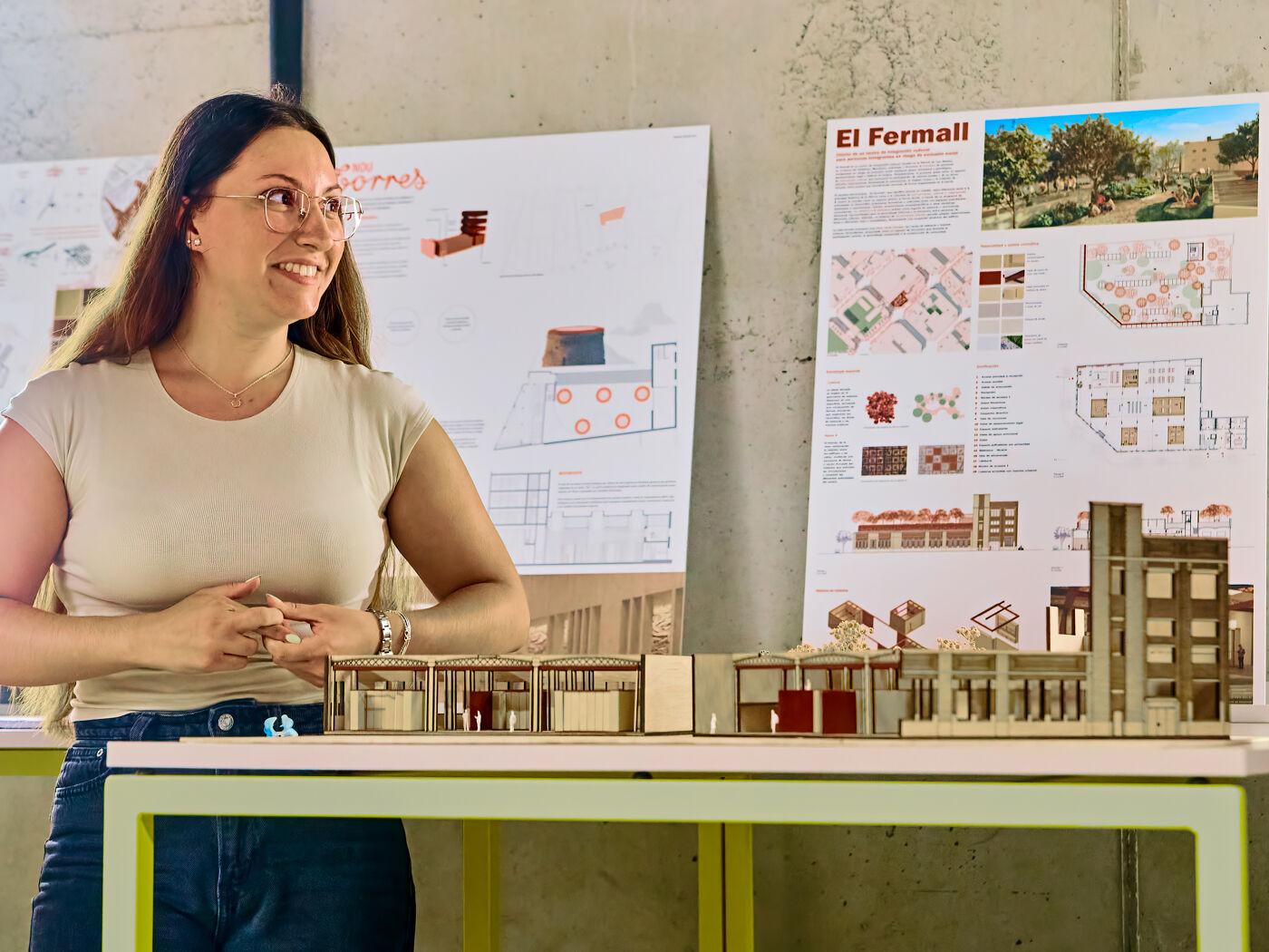 A student presents an architectural project beside a scale model and design boards during NEW'26, The Festival of New Ideas.
