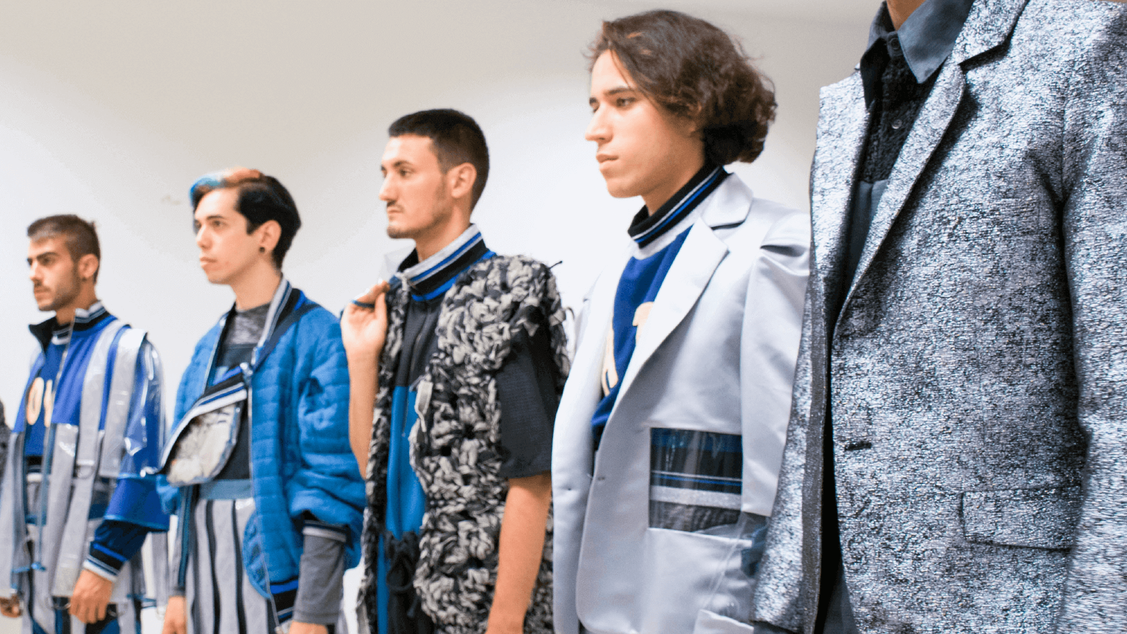 Models en una passarel·la presentant una col·lecció de moda masculina, amb dissenys moderns que barregen patrons i textures.


