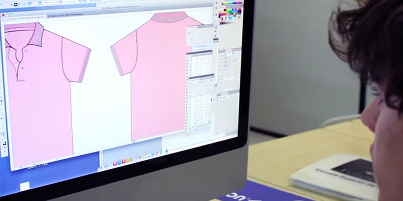 Designer working on a digital illustration of a pink polo shirt on graphic design software, emphasizing precision in fashion design.