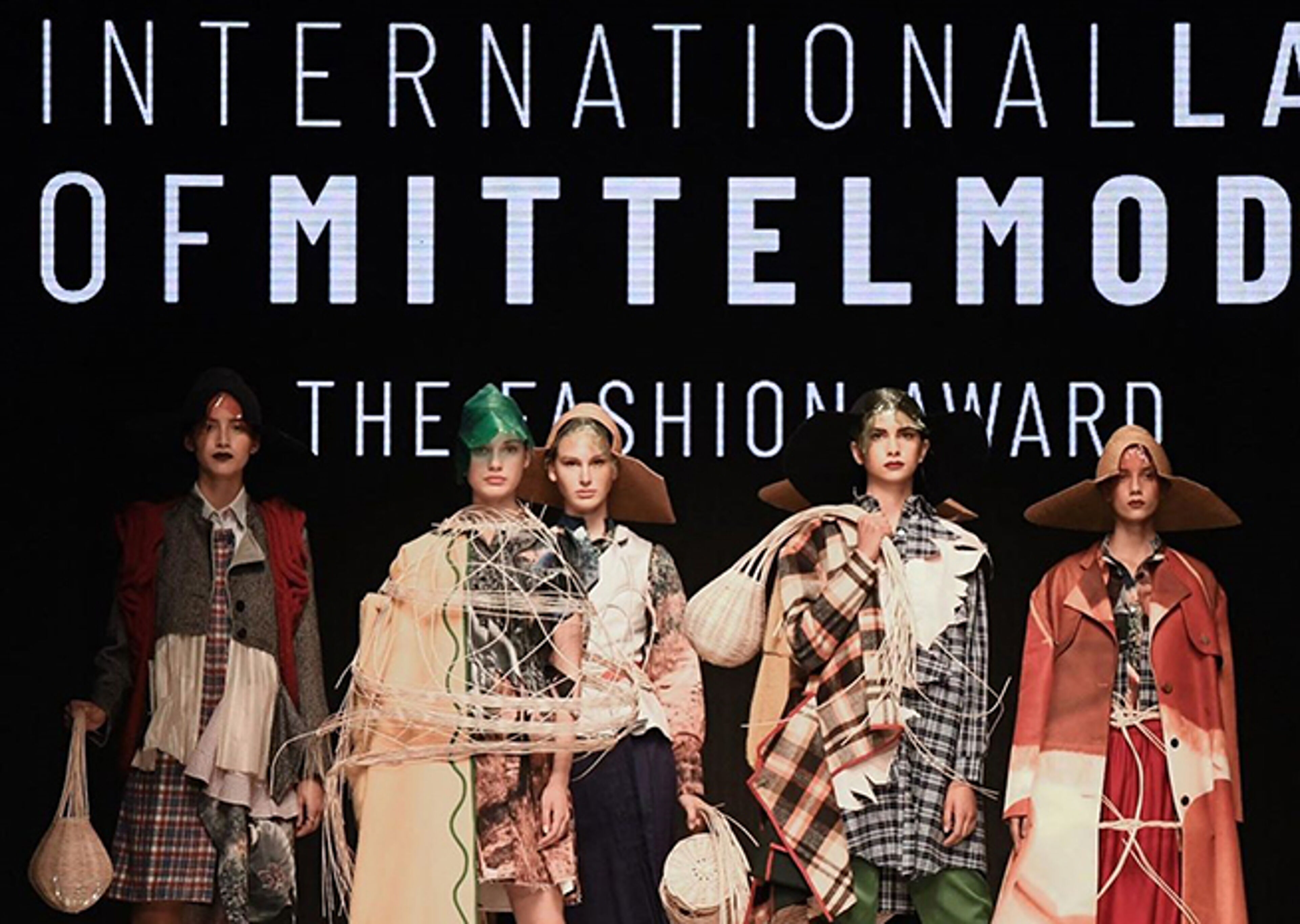 Models display eclectic designs at an international fashion show, embodying avant-garde aesthetics with a mix of patterns and textures.