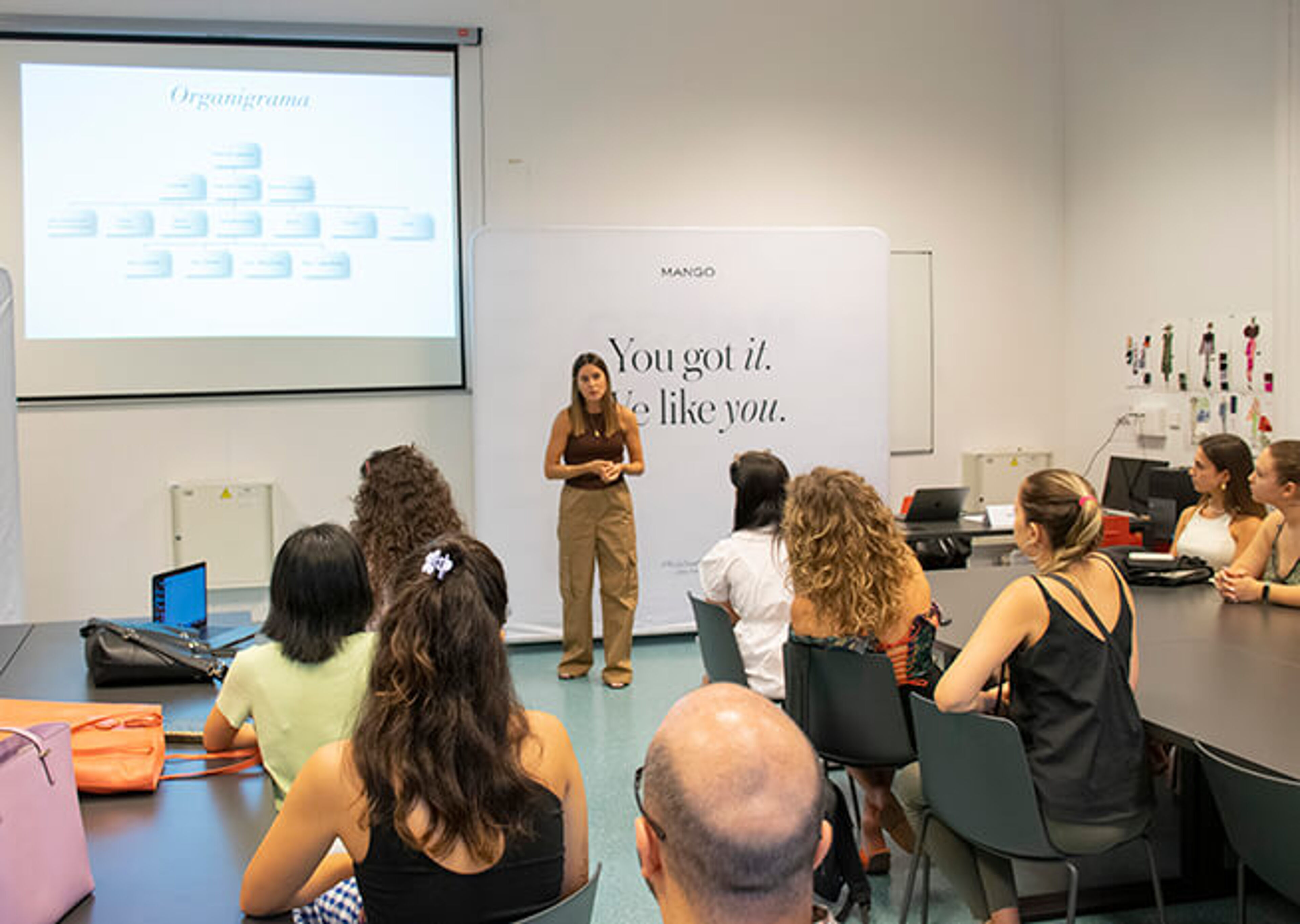 Un profesional lidera un taller de formación en una sala bien iluminada con participantes atentos.