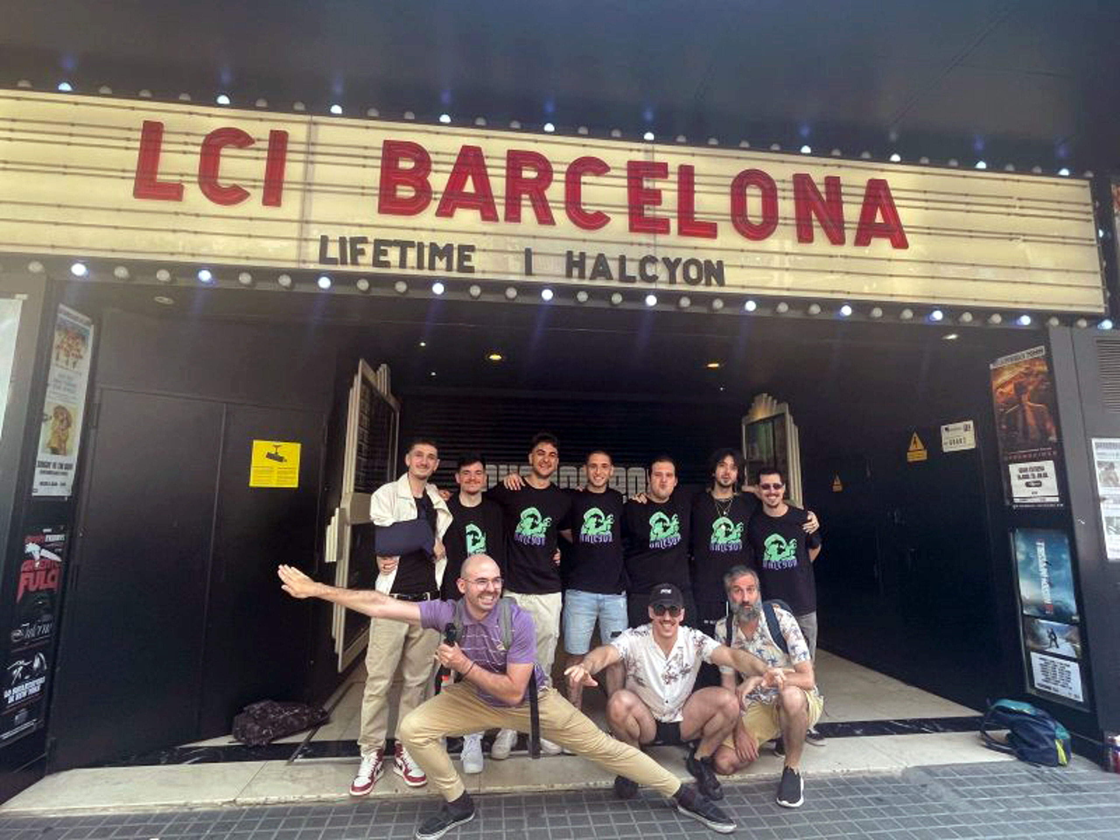 A cheerful group of people posing in front of the LCI Barcelona sign, displaying camaraderie and excitement.