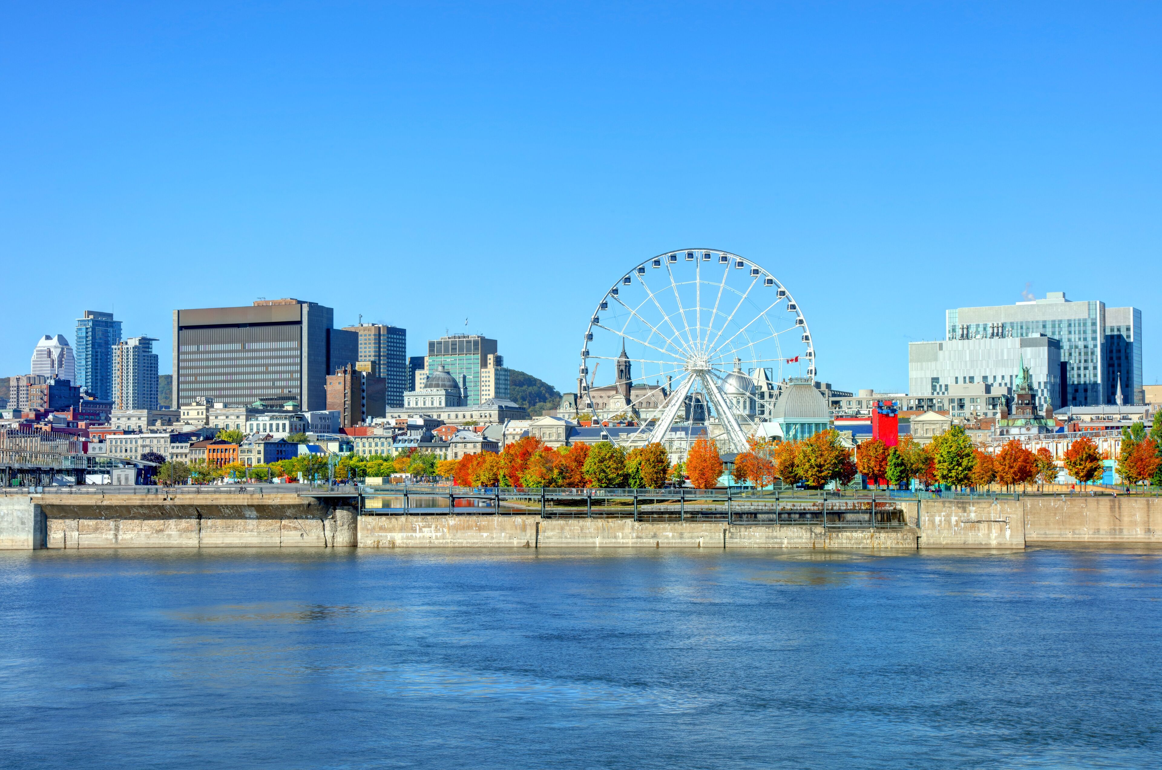 View of Montreal harbour in autumn from the St. Lawrence River, with a view of the Ferris wheel ride and the city.