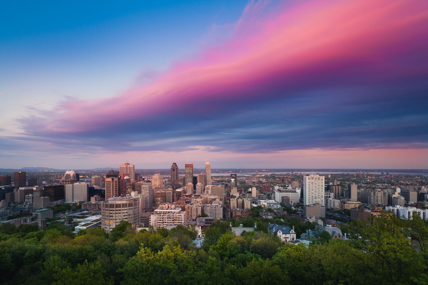 Colorful mauve, pink and blue clouds over the skyline of Montreal, Quebec, Canada.