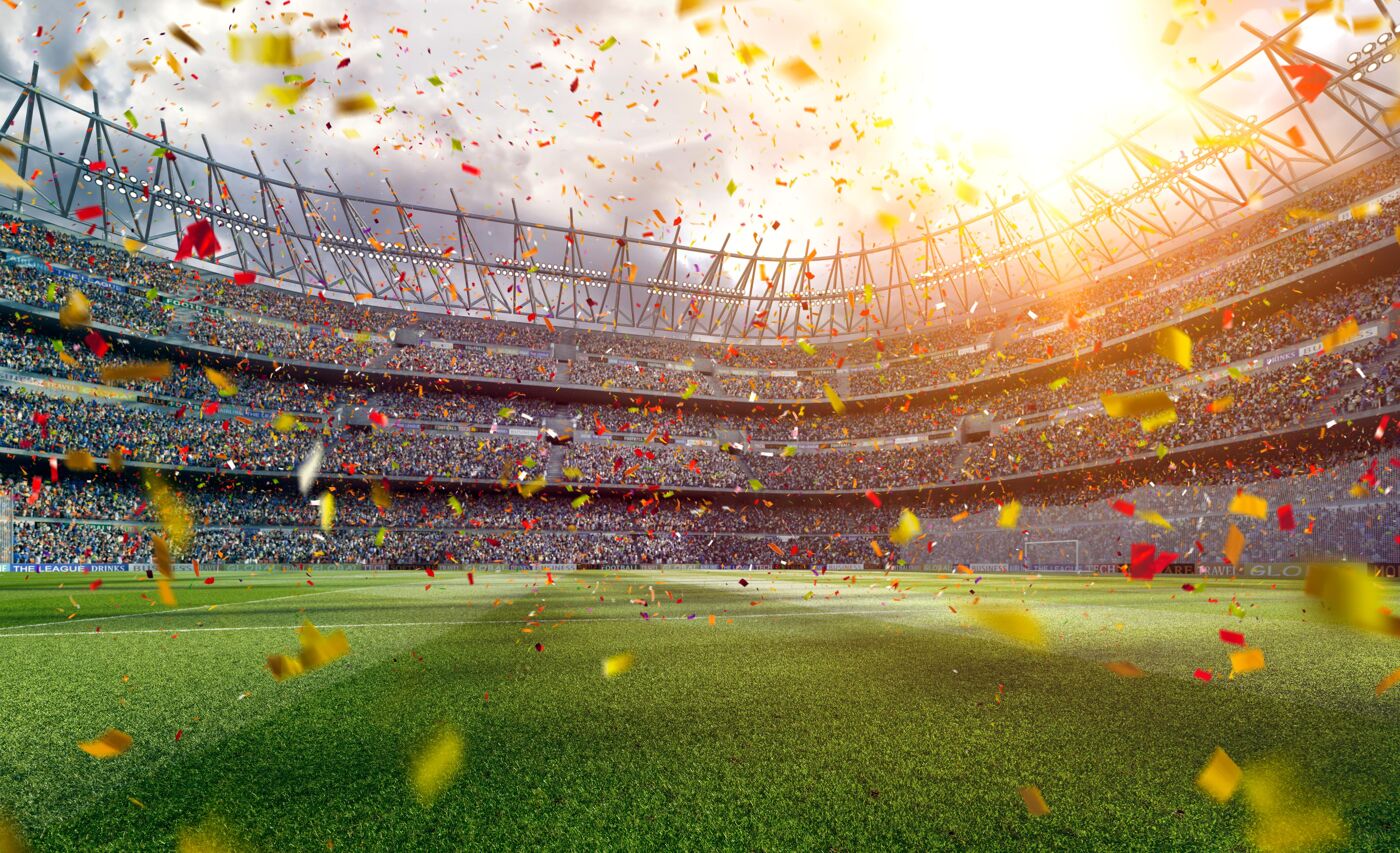 A full shot of a packed stadium with confetti raining down onto the field.