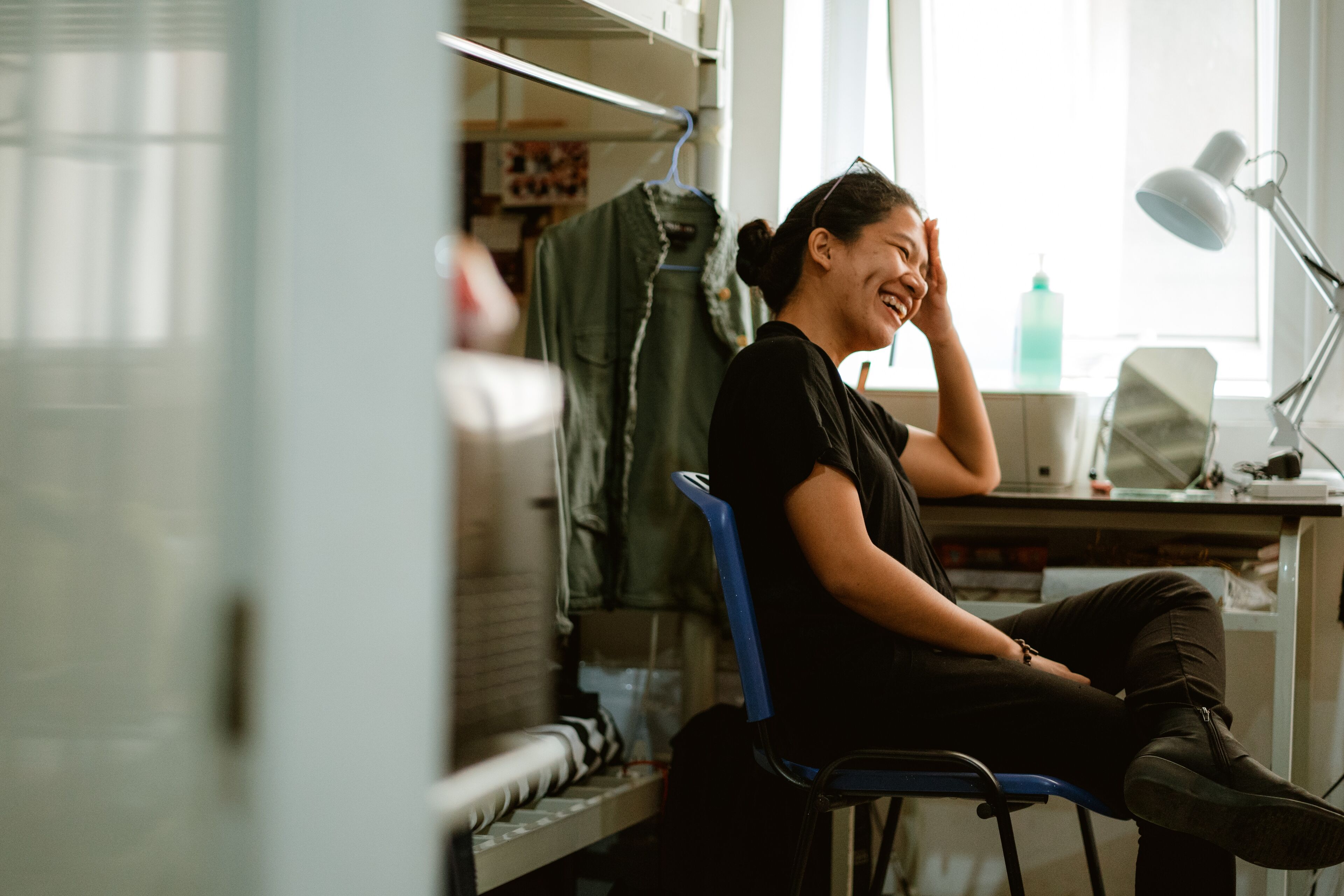 Young Filipino student sitting in her dorm room