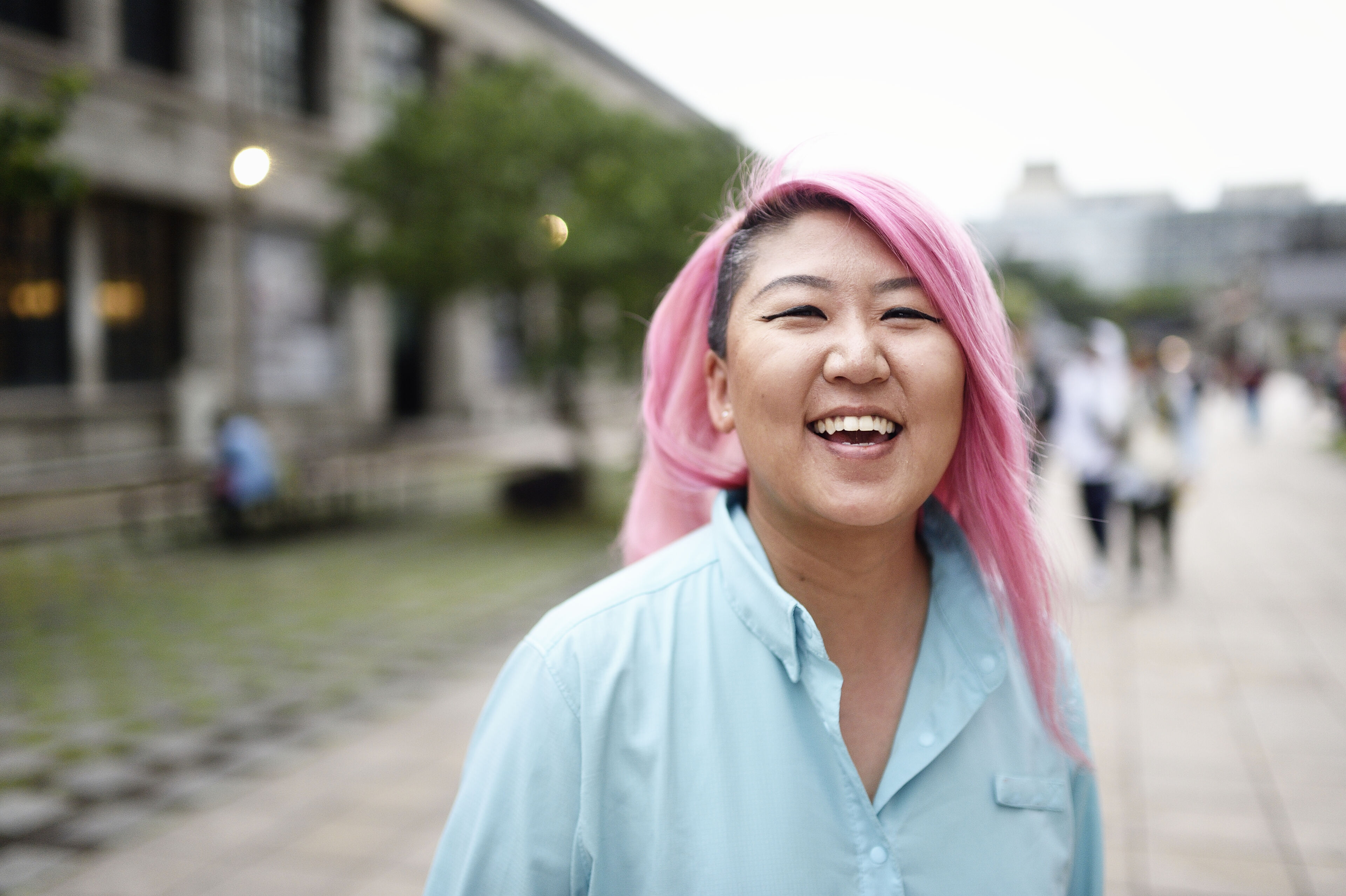 Portrait of a woman with long pink hair on a campus